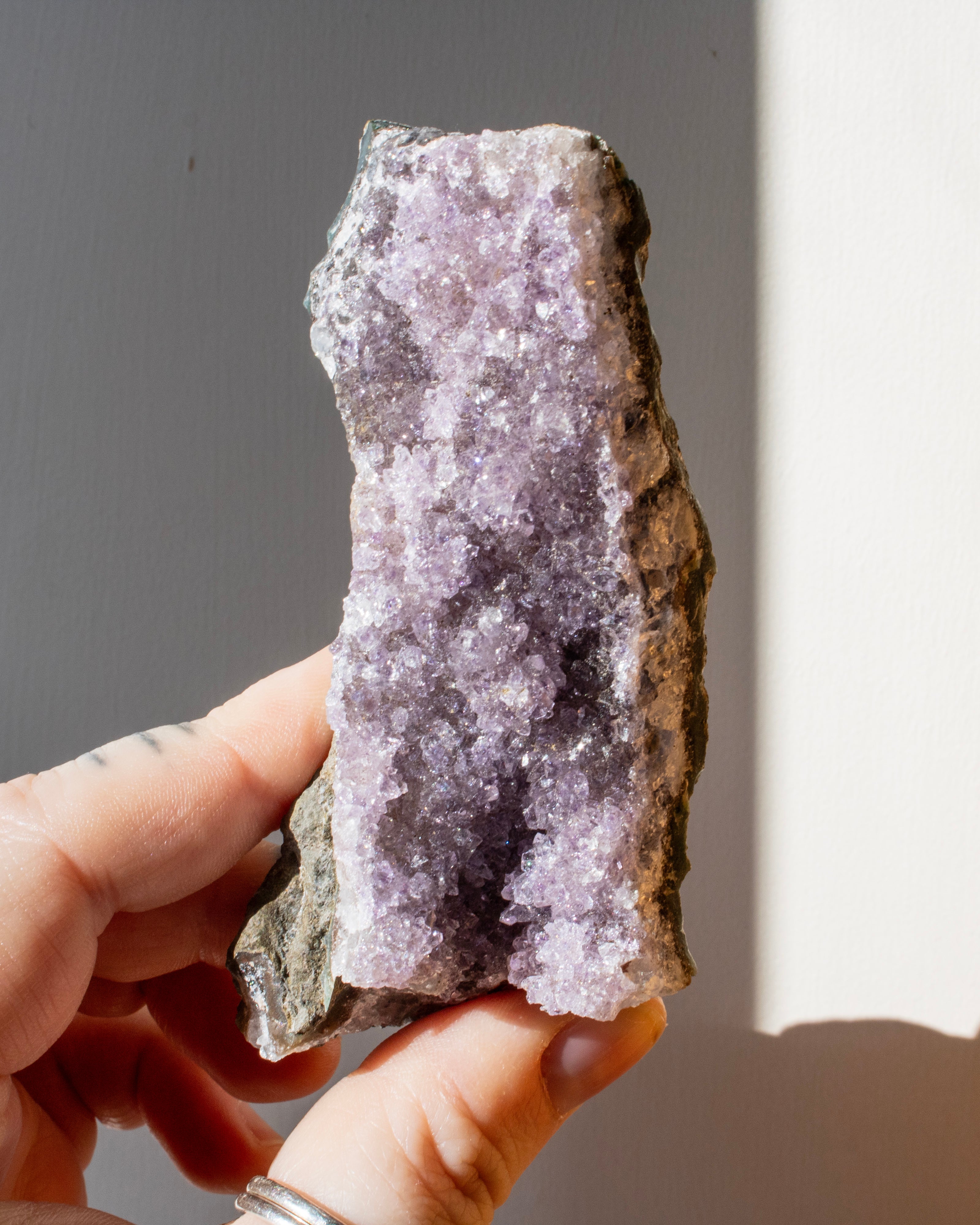 hand holding a purple amethyst cluster