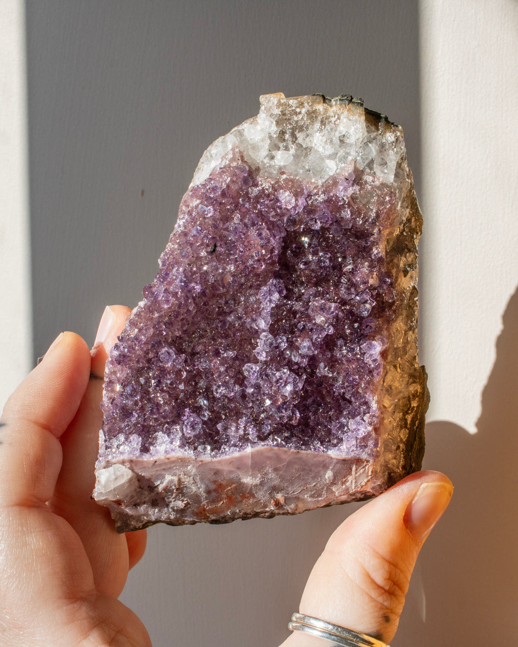 hand holding a purple amethyst cluster
