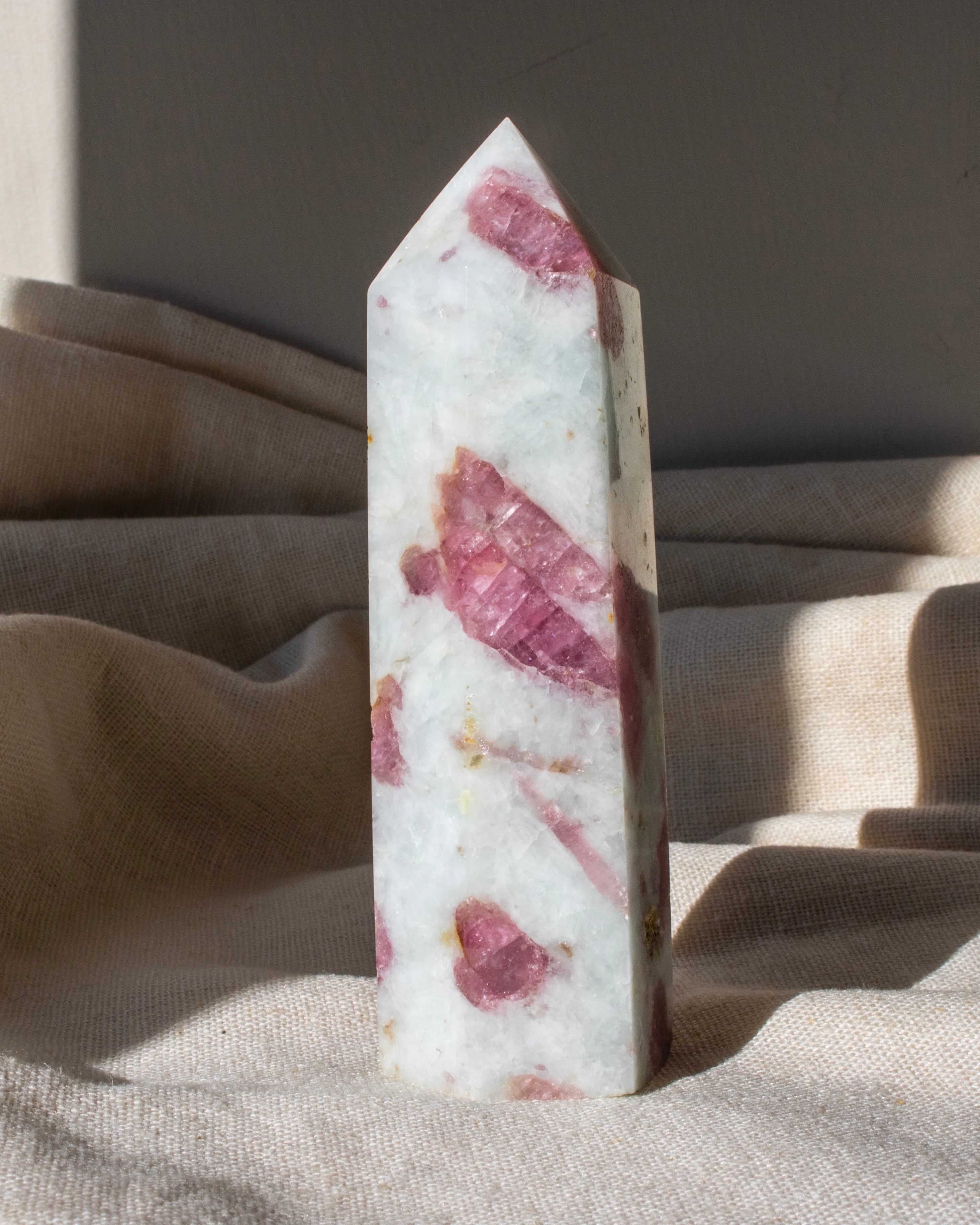 a tall pointed white stone with pink areas 