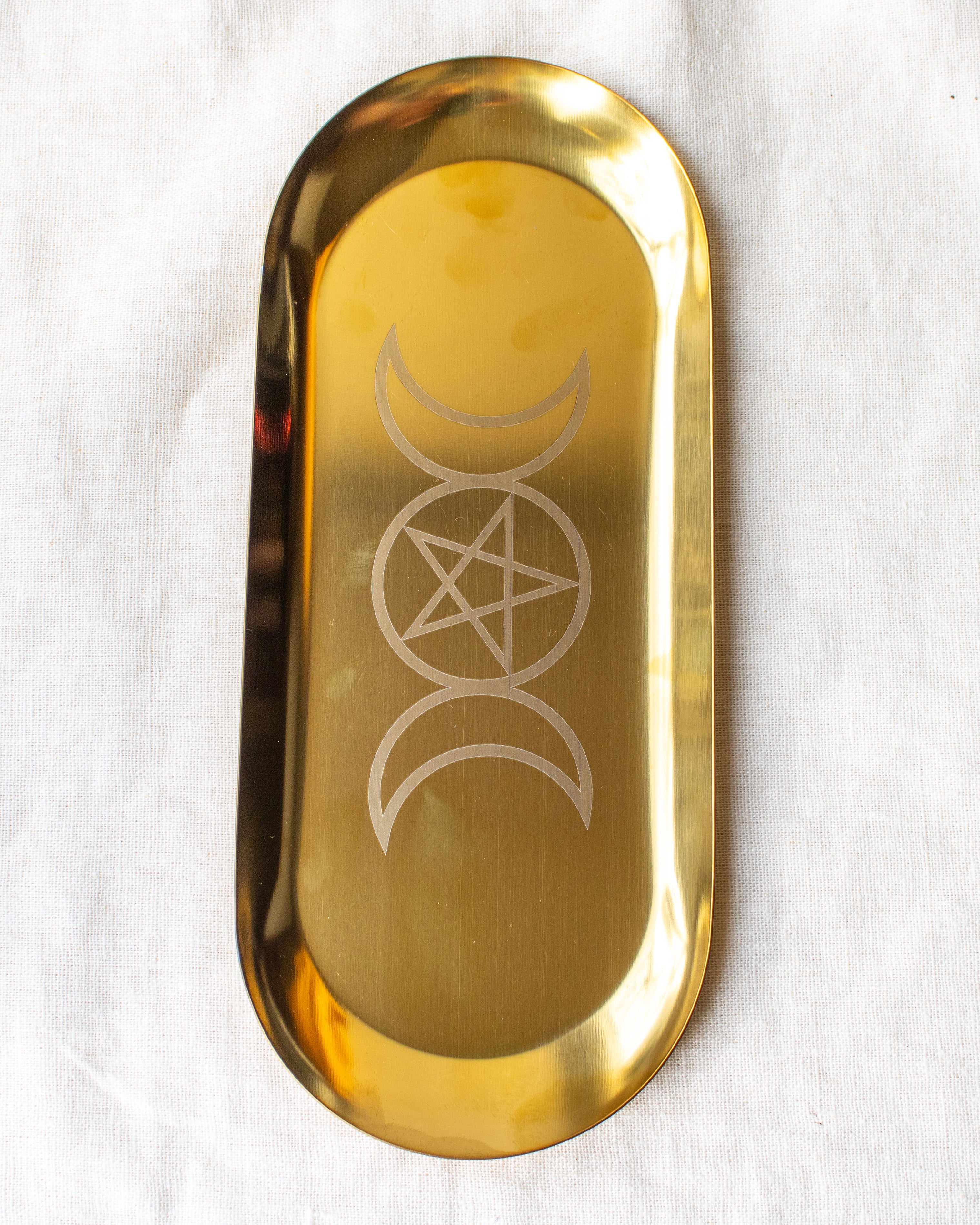 a long metal tray with 2 crescent moons joined either side of a circle with a pentagram inside