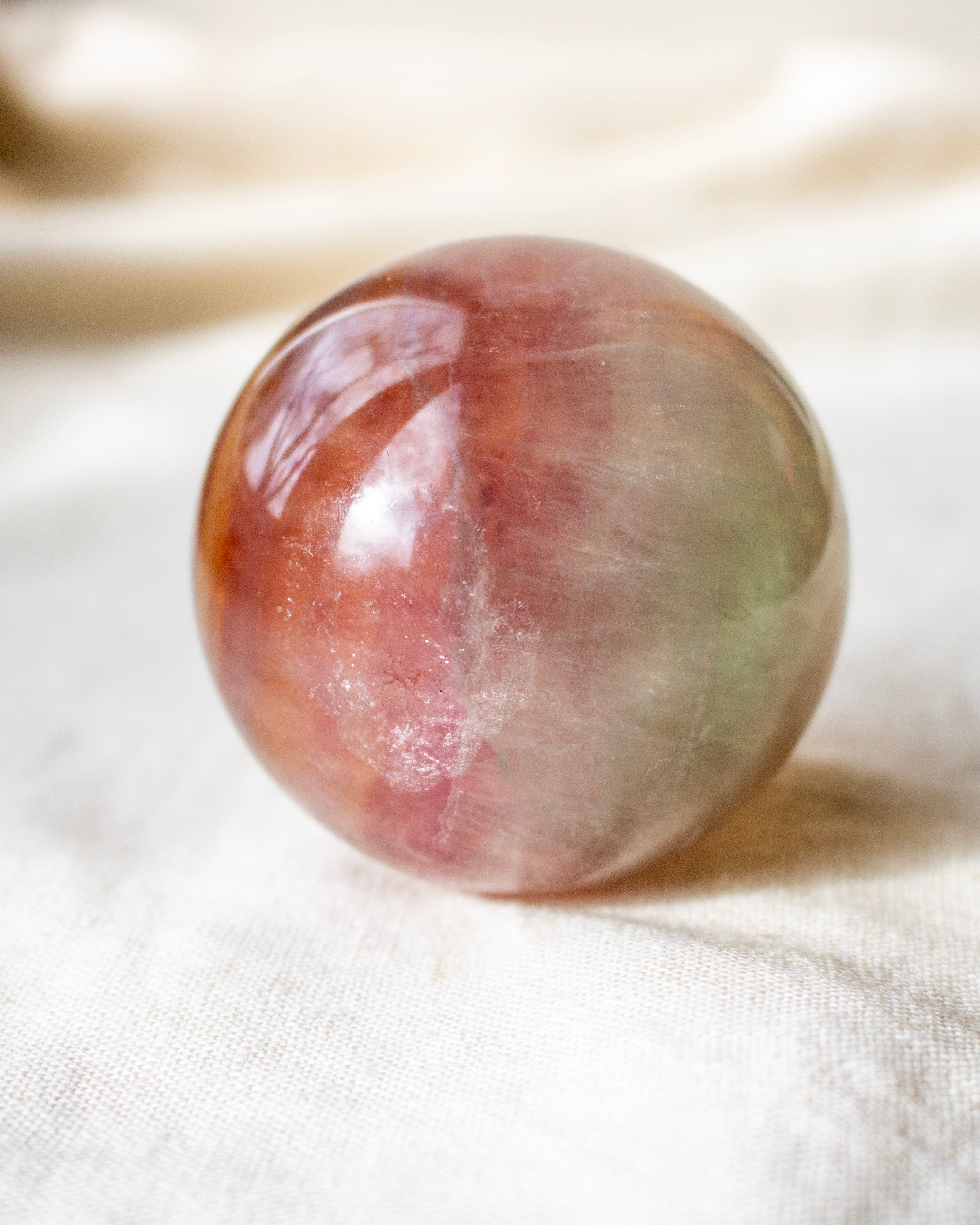Multicolored stone sphere on a white fabric background
