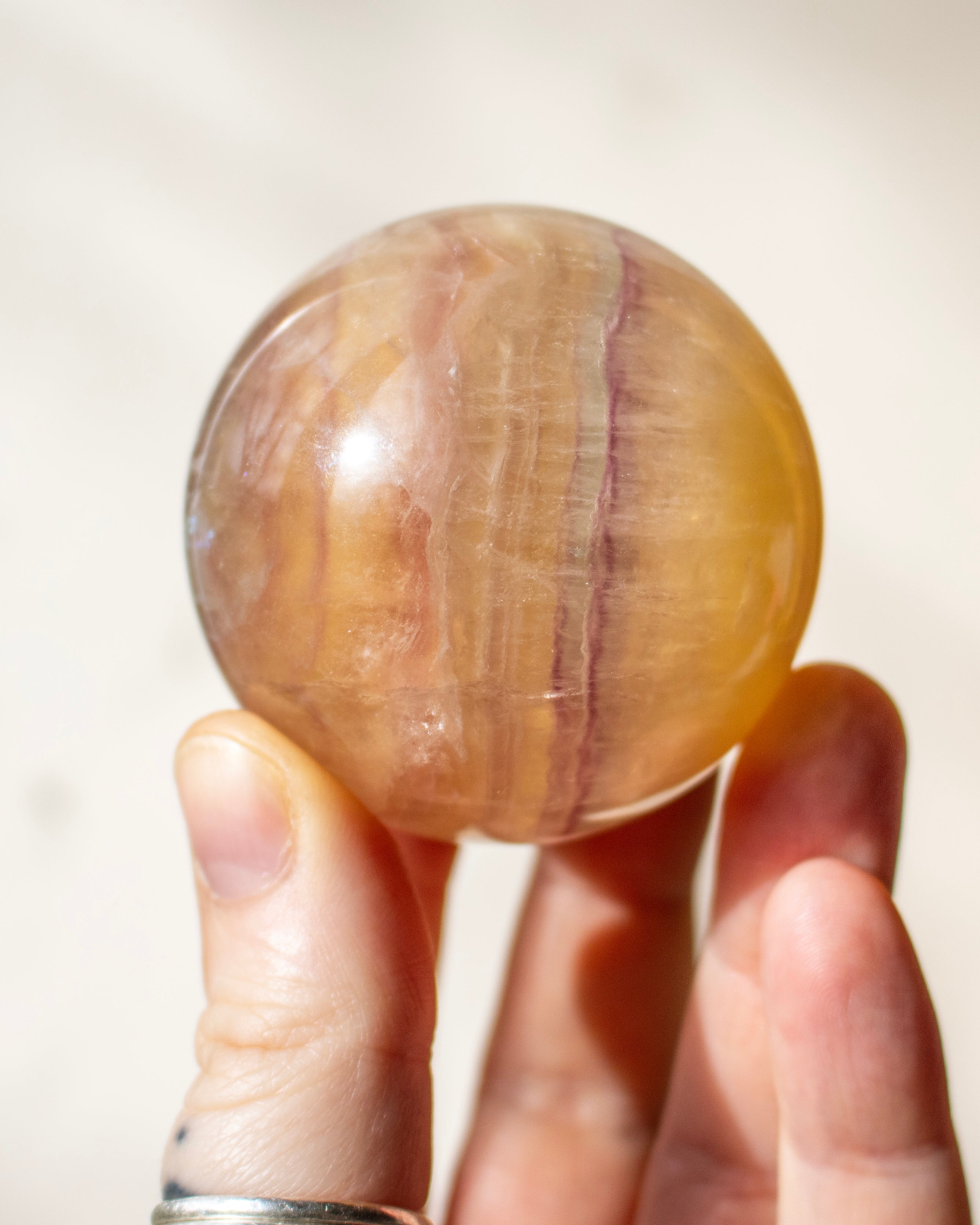 yellow and purple crystal ball being held in a hand