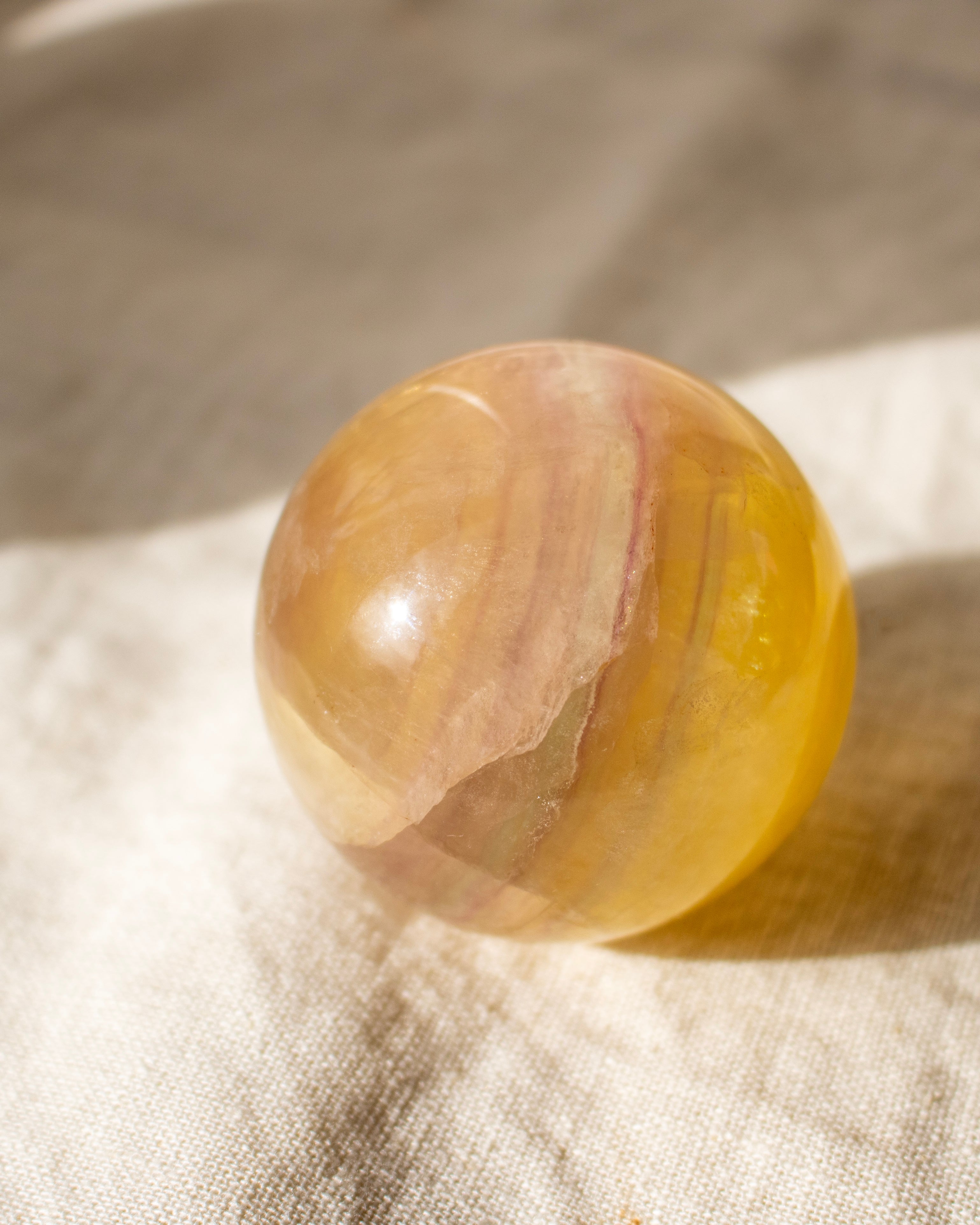 a yellow crystal ball on a linen fabric background