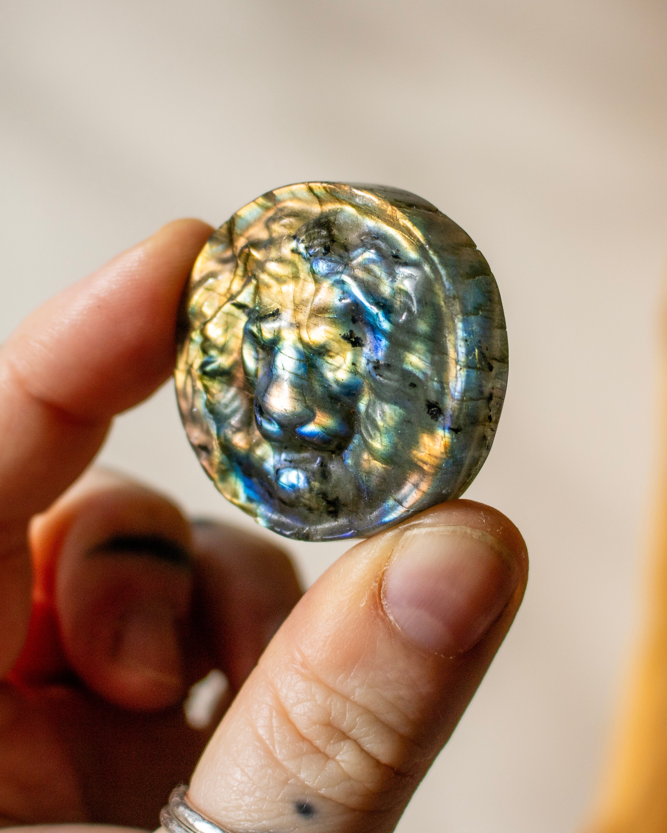 Hand holding a labradorite stone with iridescent patterns