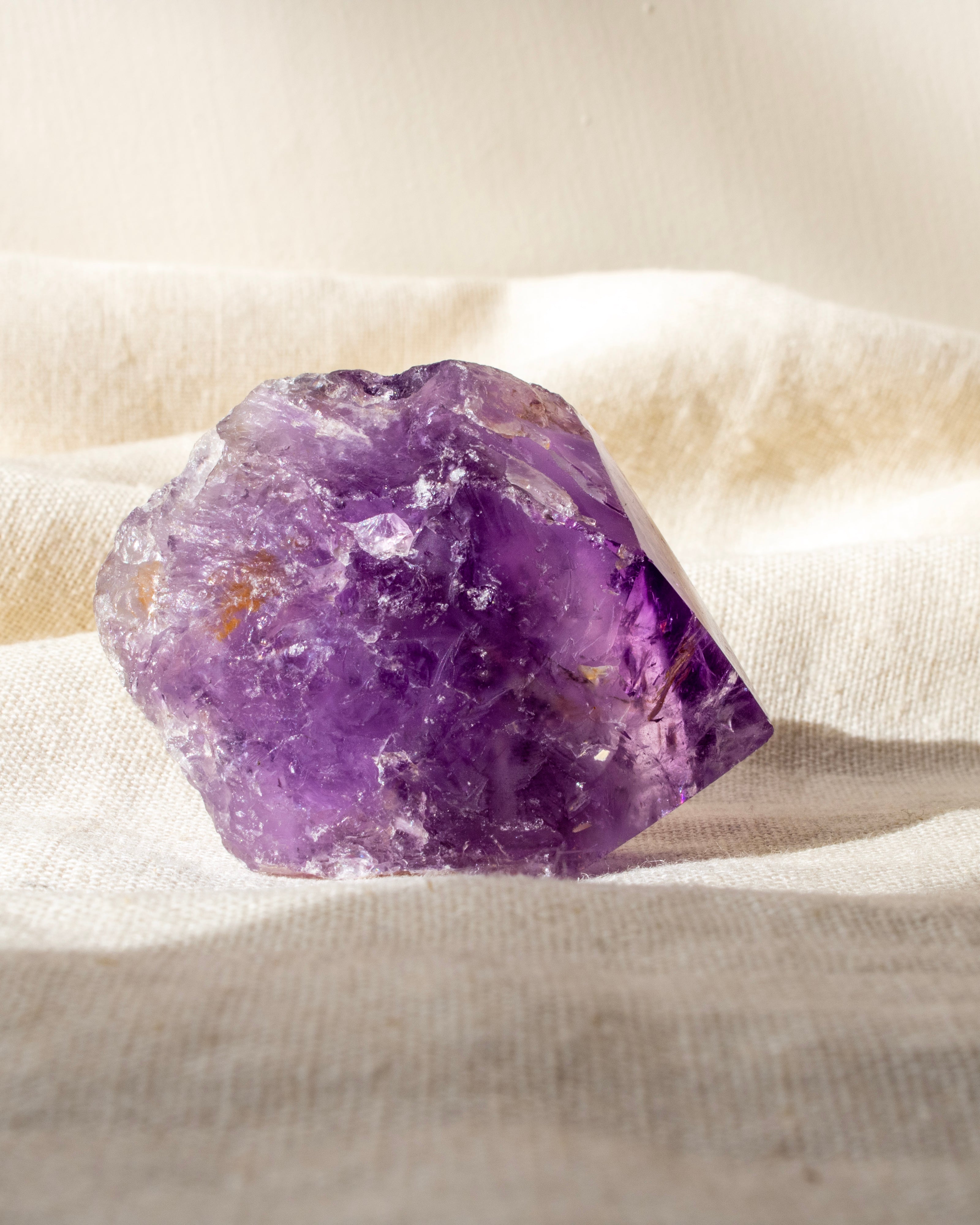 purple amethyst crystal on a beige fabric background