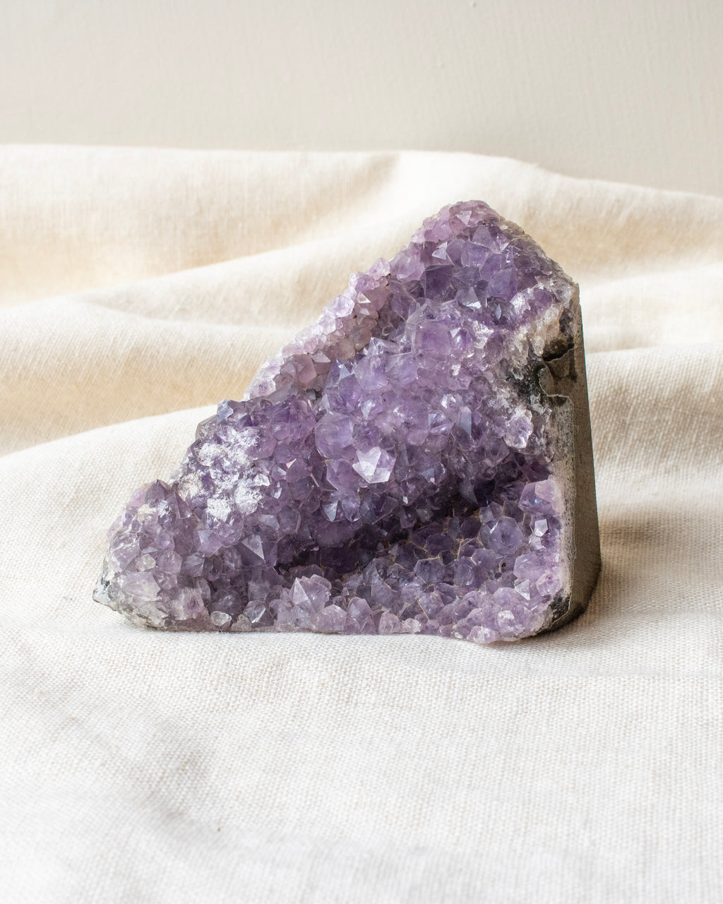 Purple crystal rock on a white fabric surface