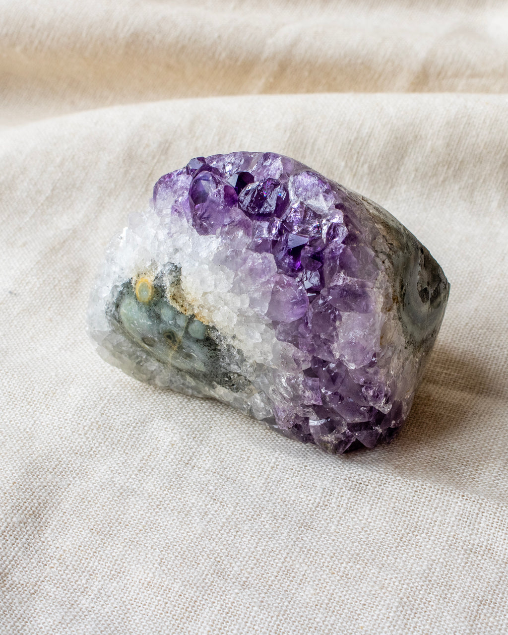 Amethyst crystal on a beige fabric background