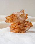 Orange quartz crystal rock on a white fabric background