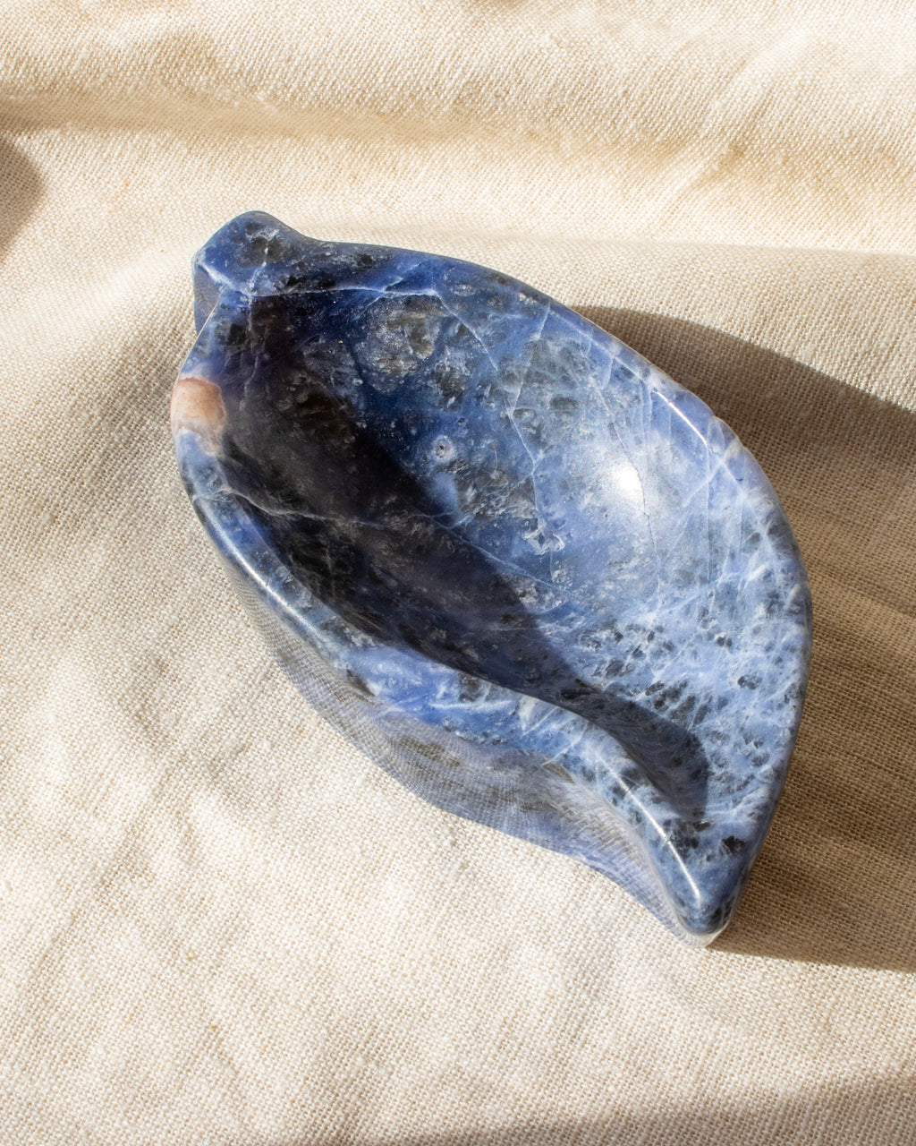 Blue stone bowl on a beige fabric background