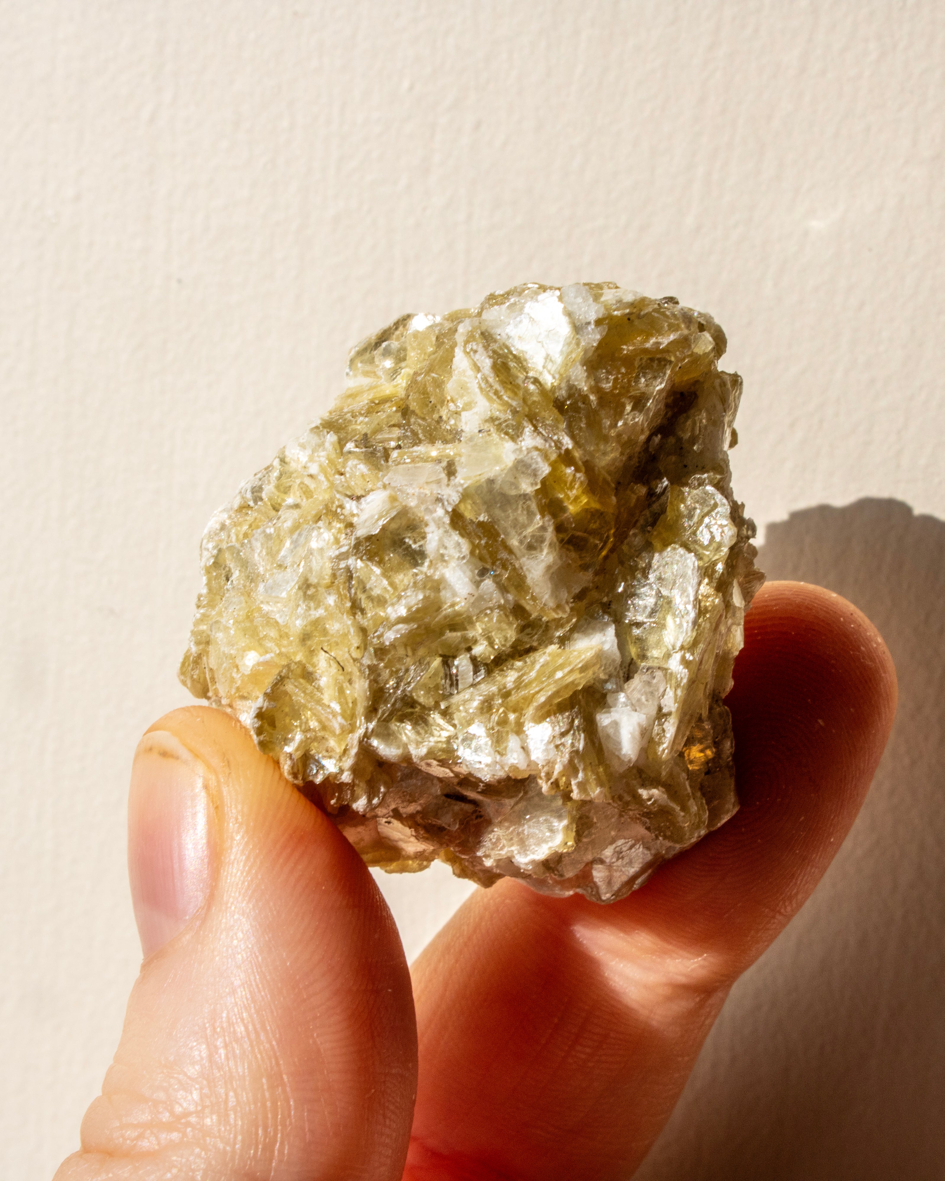 Mineral sample held between fingers against a neutral background