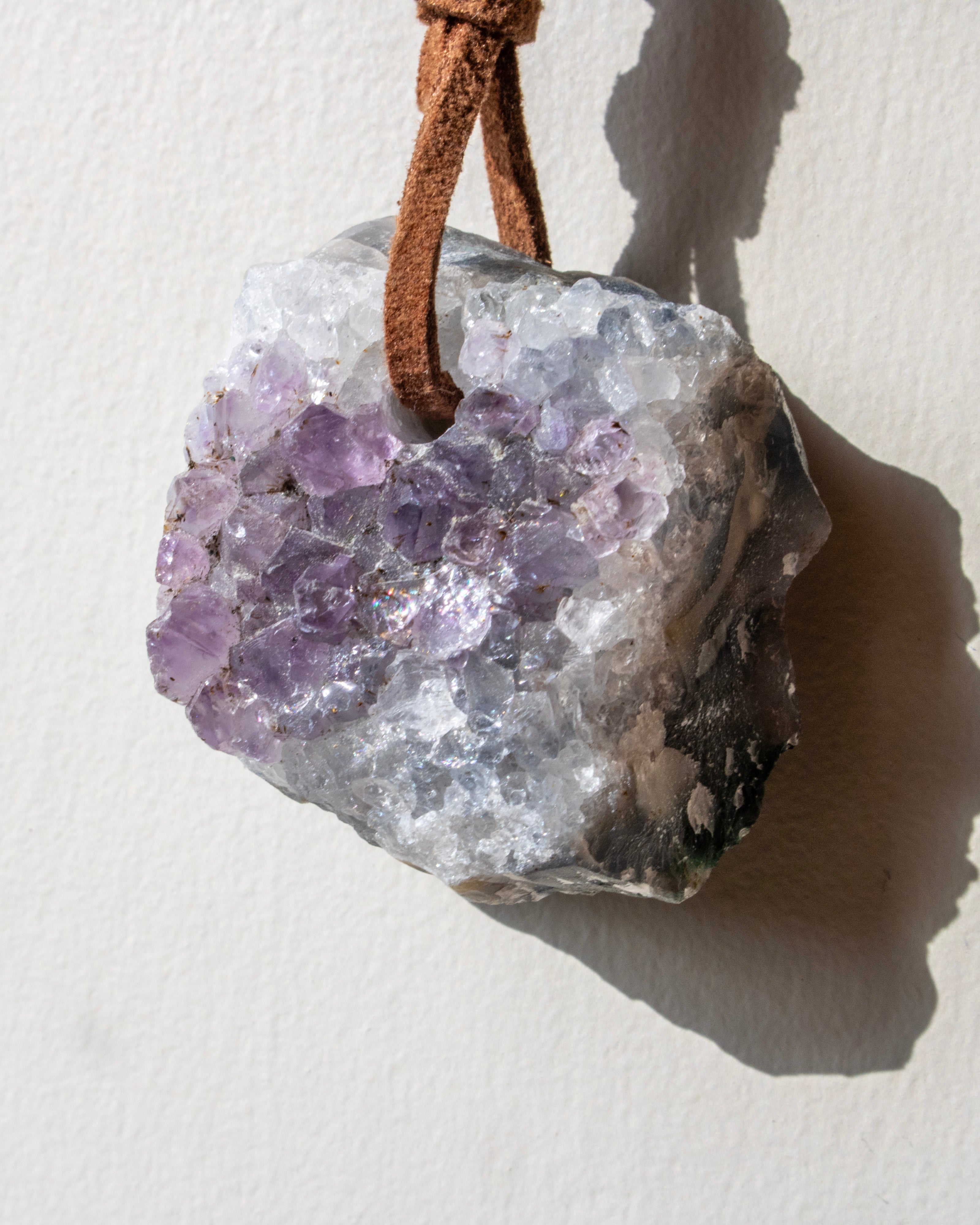 Amethyst crystal pendant on a white background