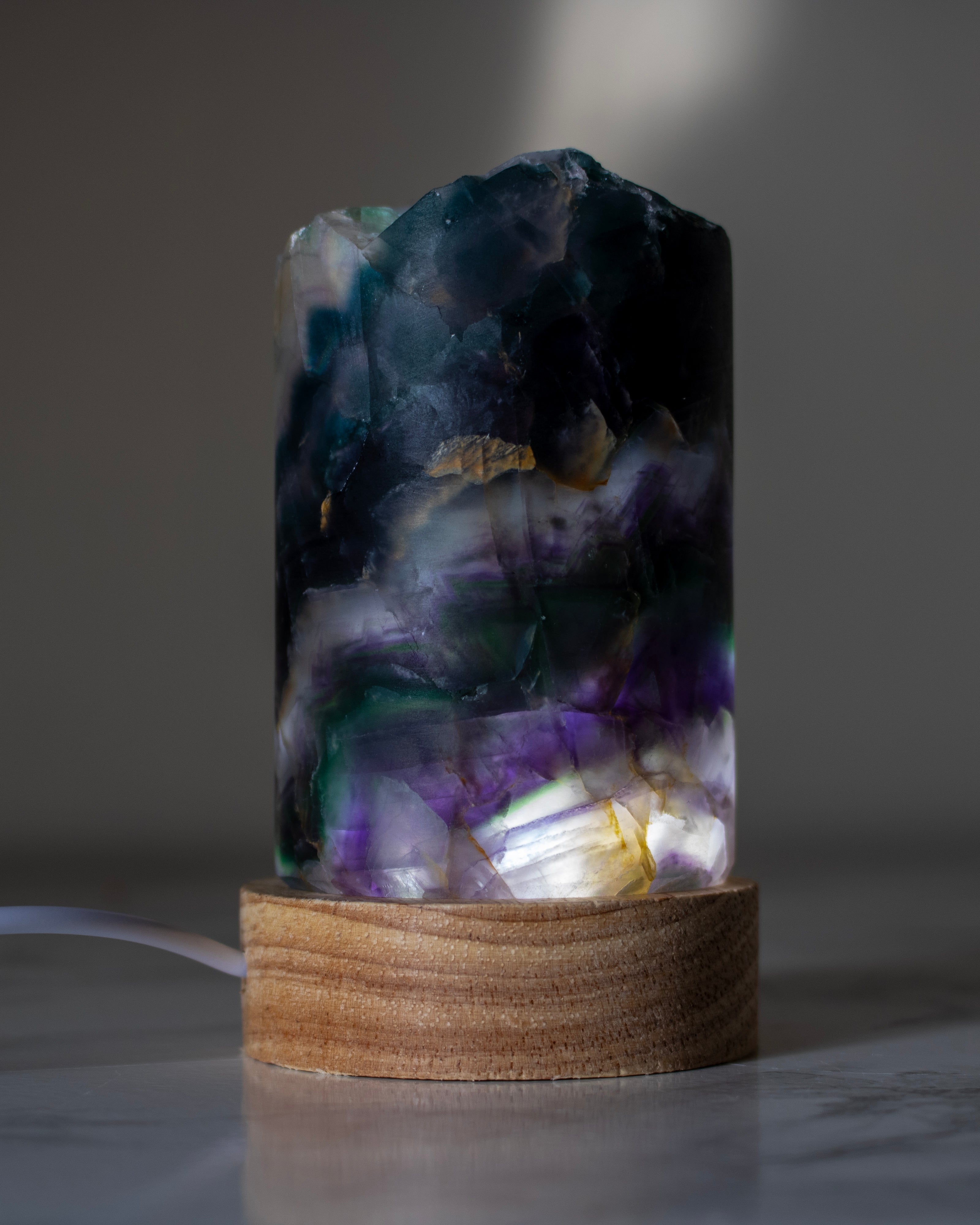 Decorative lamp with a natural stone design on a wooden base against a neutral background