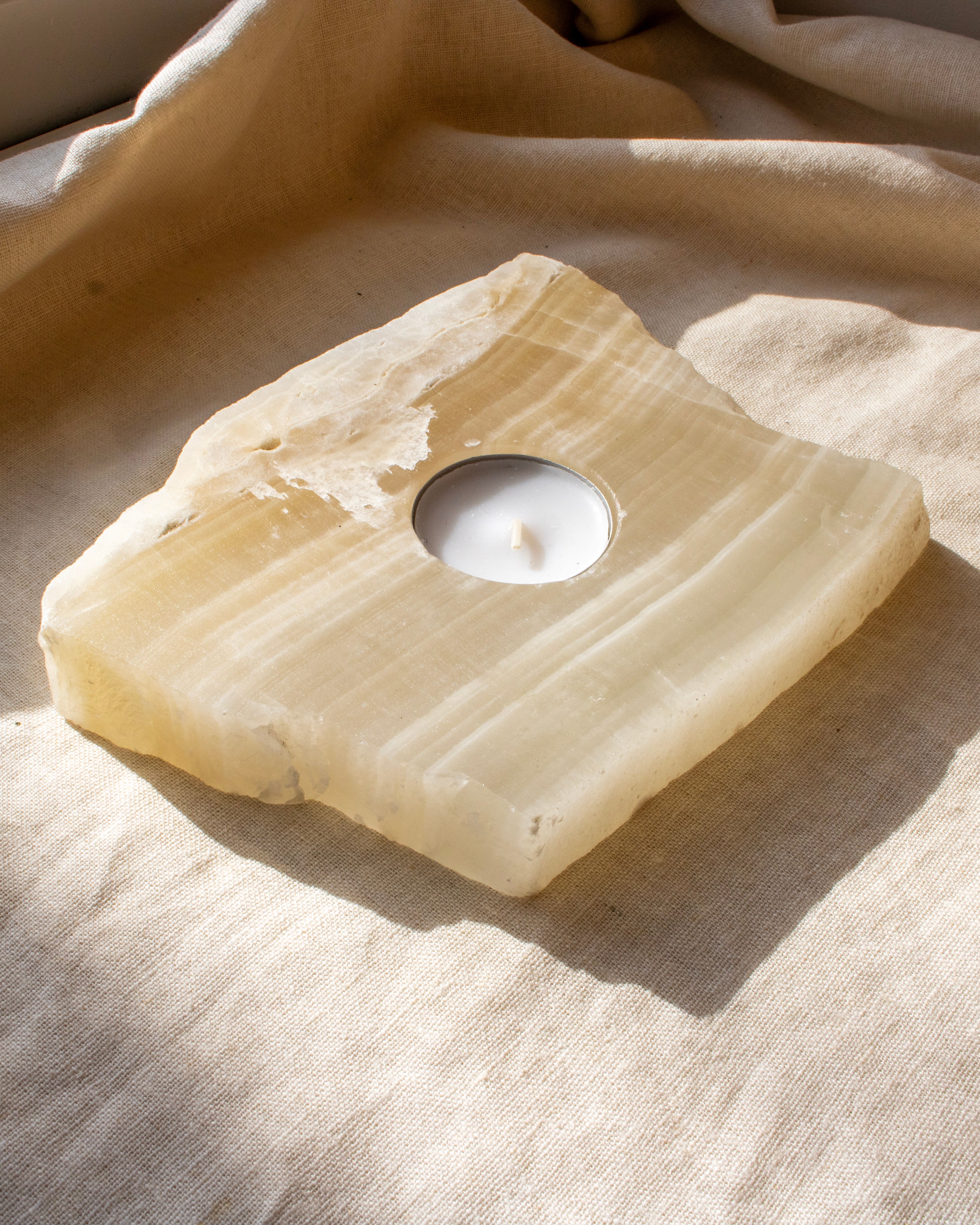 Candle holder made of stone on a textured fabric surface