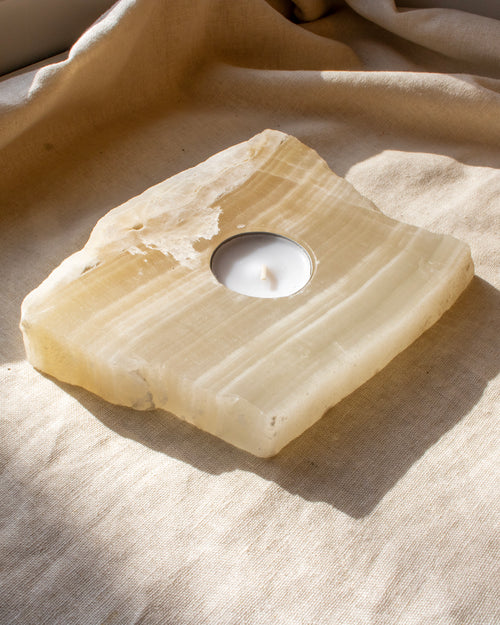 Candle holder made of stone on a textured fabric surface