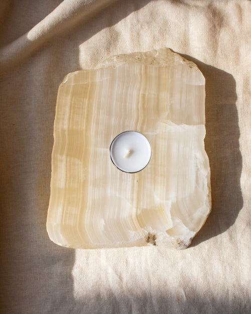 Tealight candle inside a large crystal on a textured surface