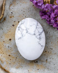 White marbled stone on a textured surface with purple flowers