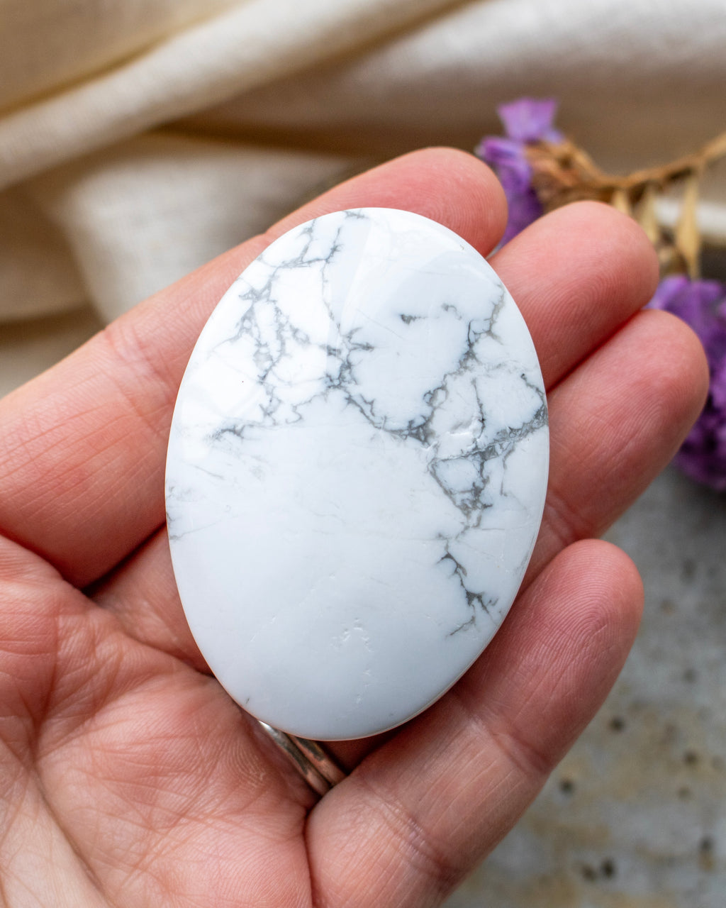 Marble-patterned stone held in a hand with a blurred background