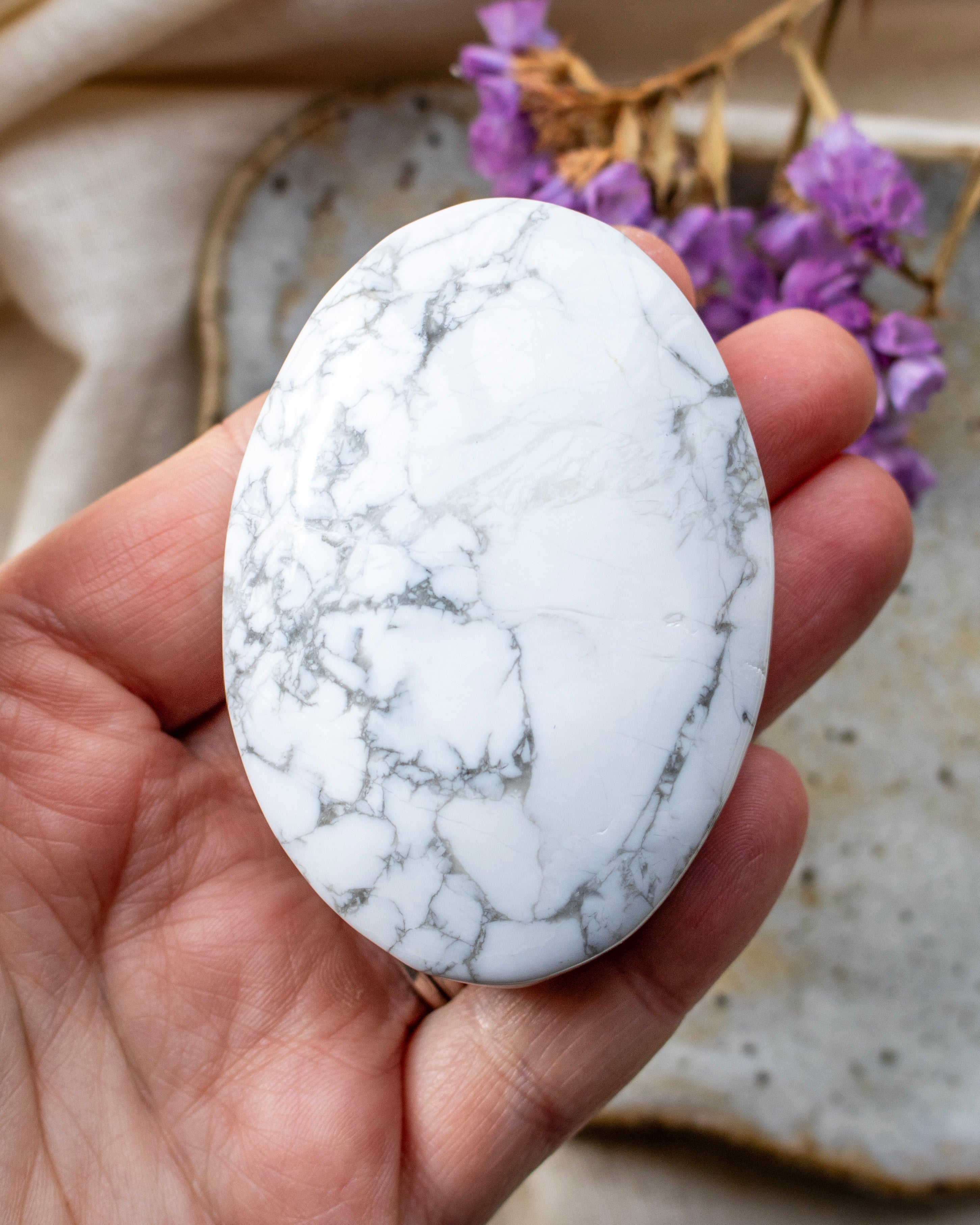 Marble-patterned stone held in a hand with a blurred background