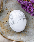 Marble-patterned stone on a textured ceramic plate with purple flowers