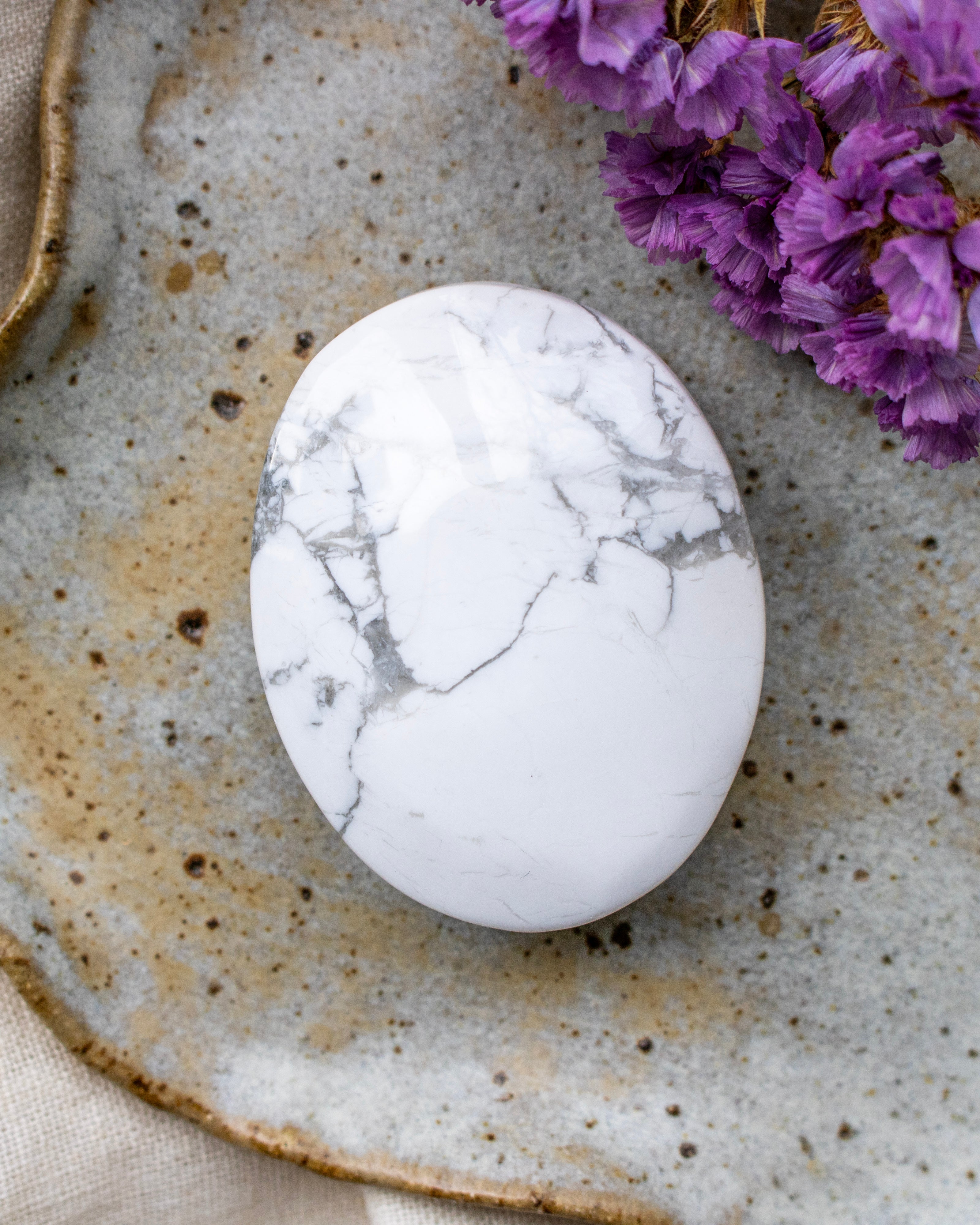 Marble-patterned stone on a textured ceramic plate with purple flowers