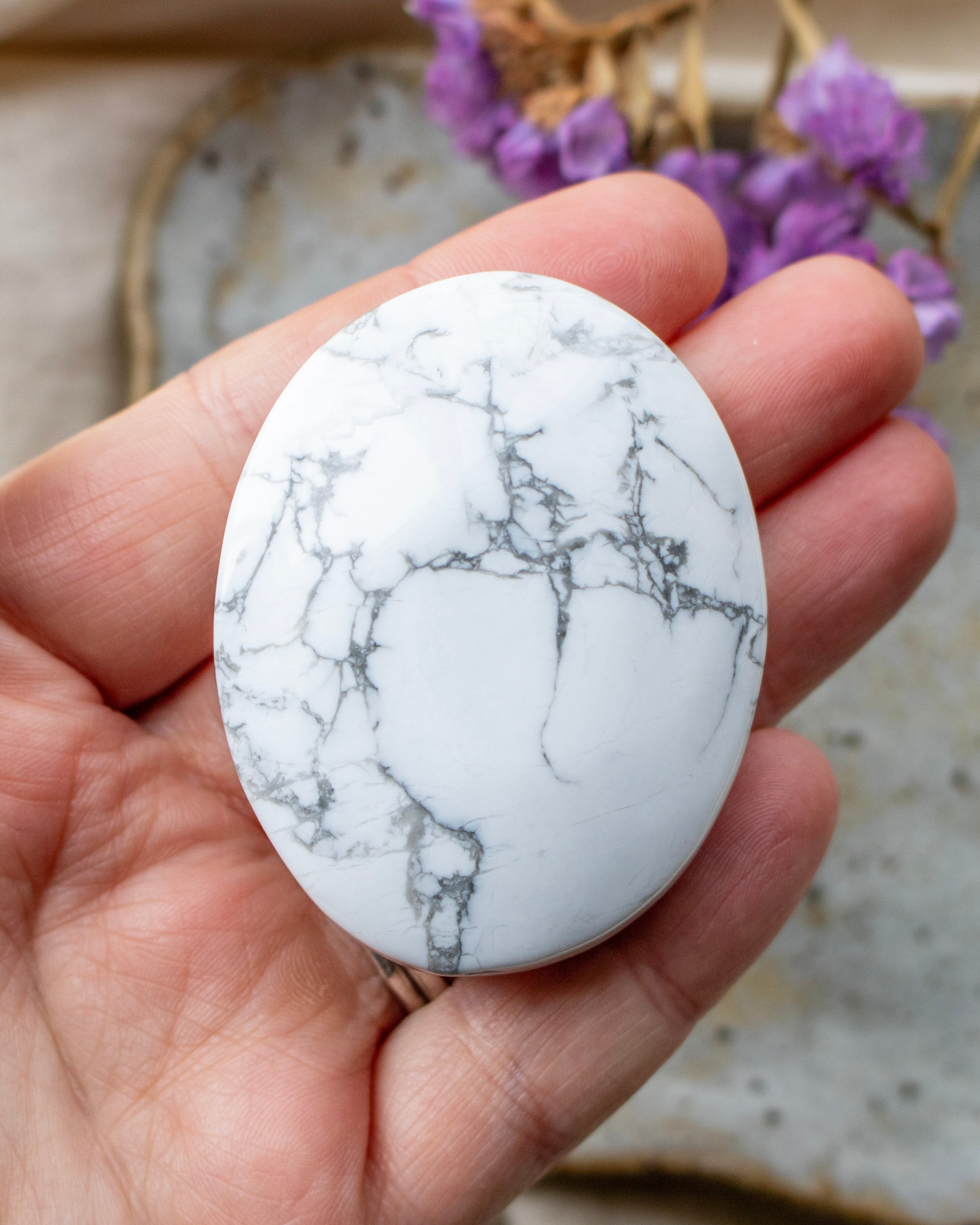 Marble-patterned stone held in a hand with a blurred background