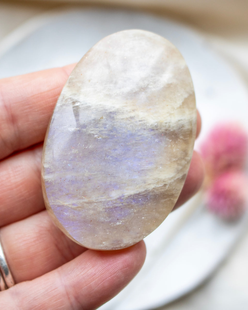 Multicolored stone held in a hand with a blurred background