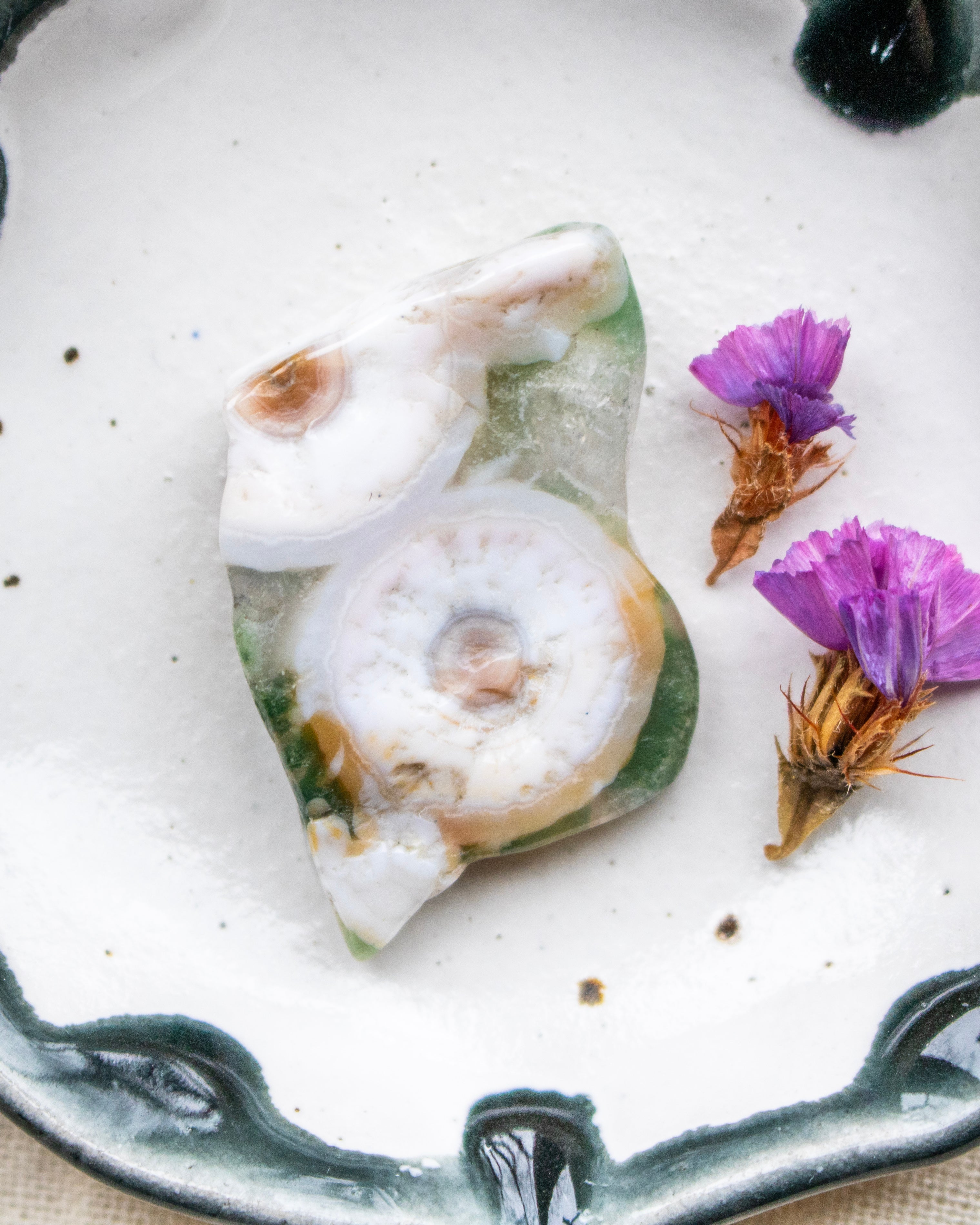 white decorative stone with purple flowers on a white plate