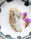 Decorative stone with purple flowers on a white surface