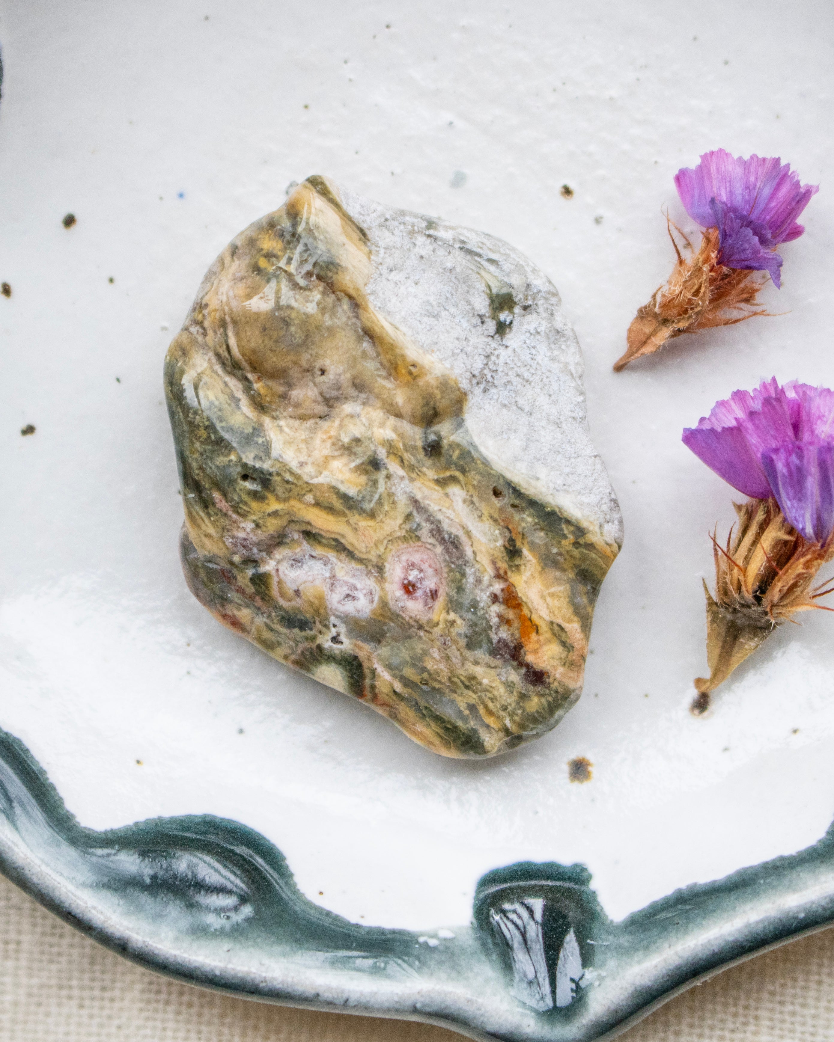Decorative stone on a ceramic plate with purple flowers