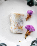 Marbled stone with purple flowers on a textured surface