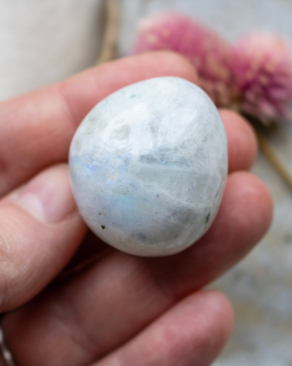 White stone held in a hand with a blurred background