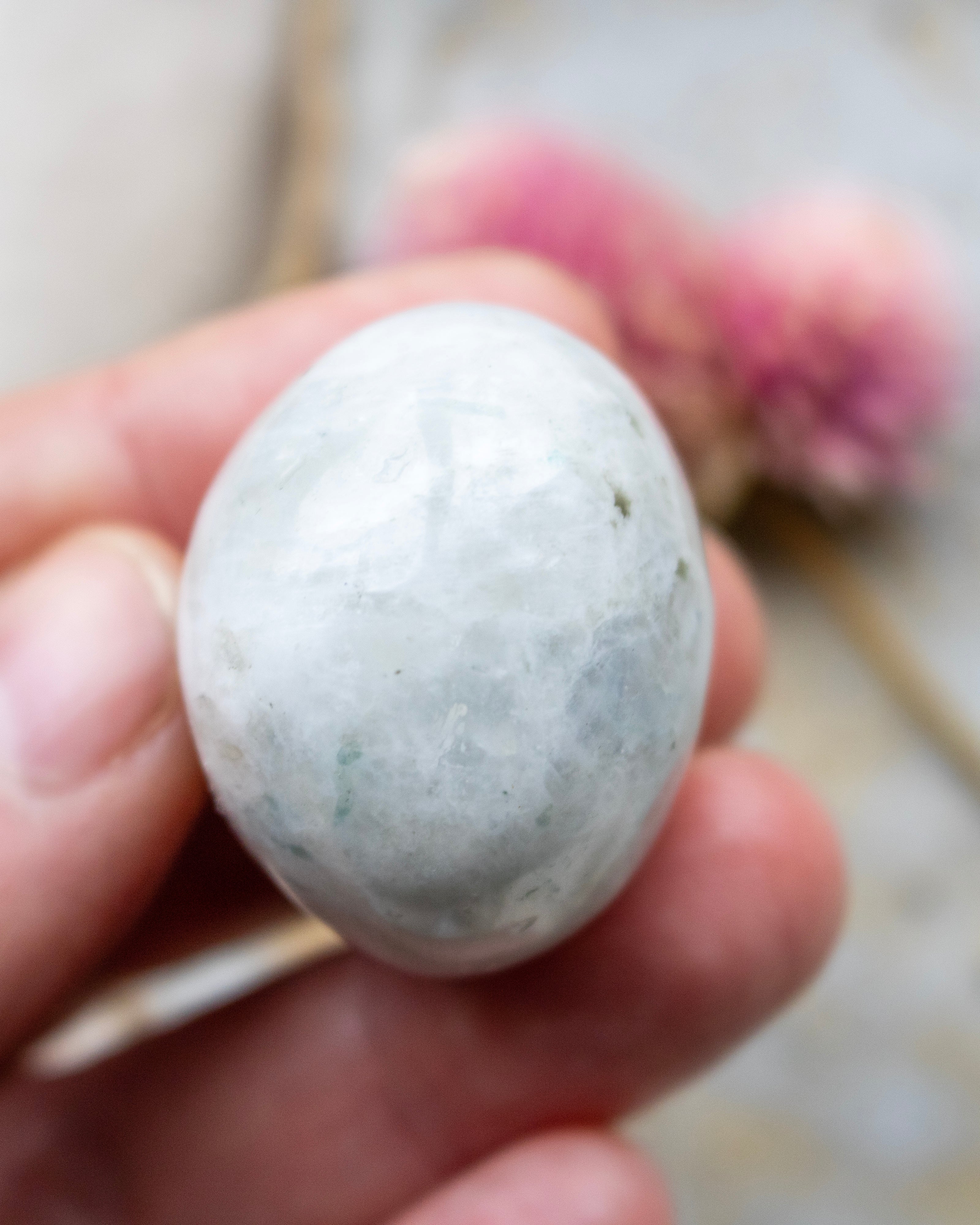 Hand holding a small stone with a blurred background