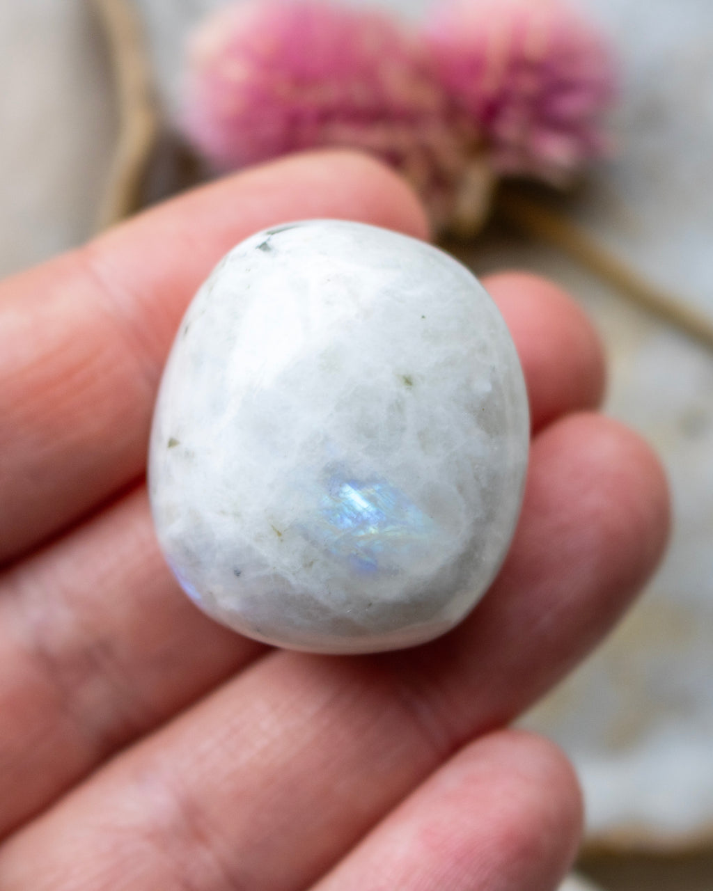 Polished stone held in a hand with a blurred background