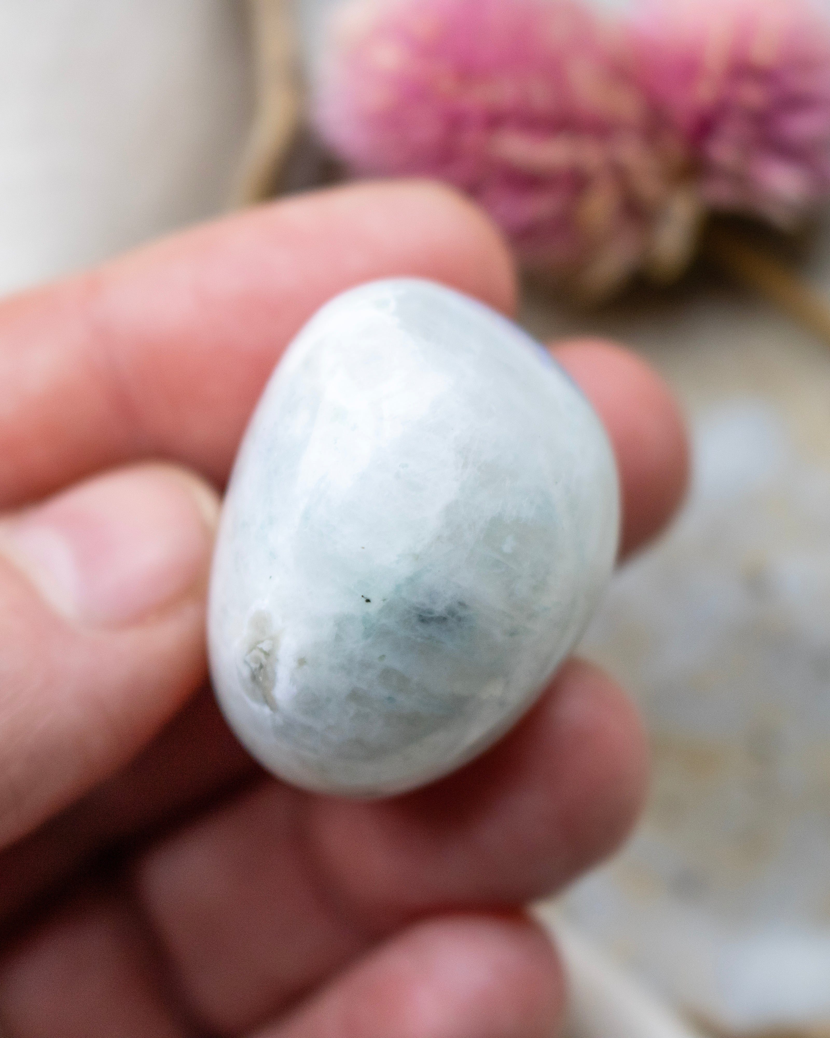 White stone held in a hand with a blurred background