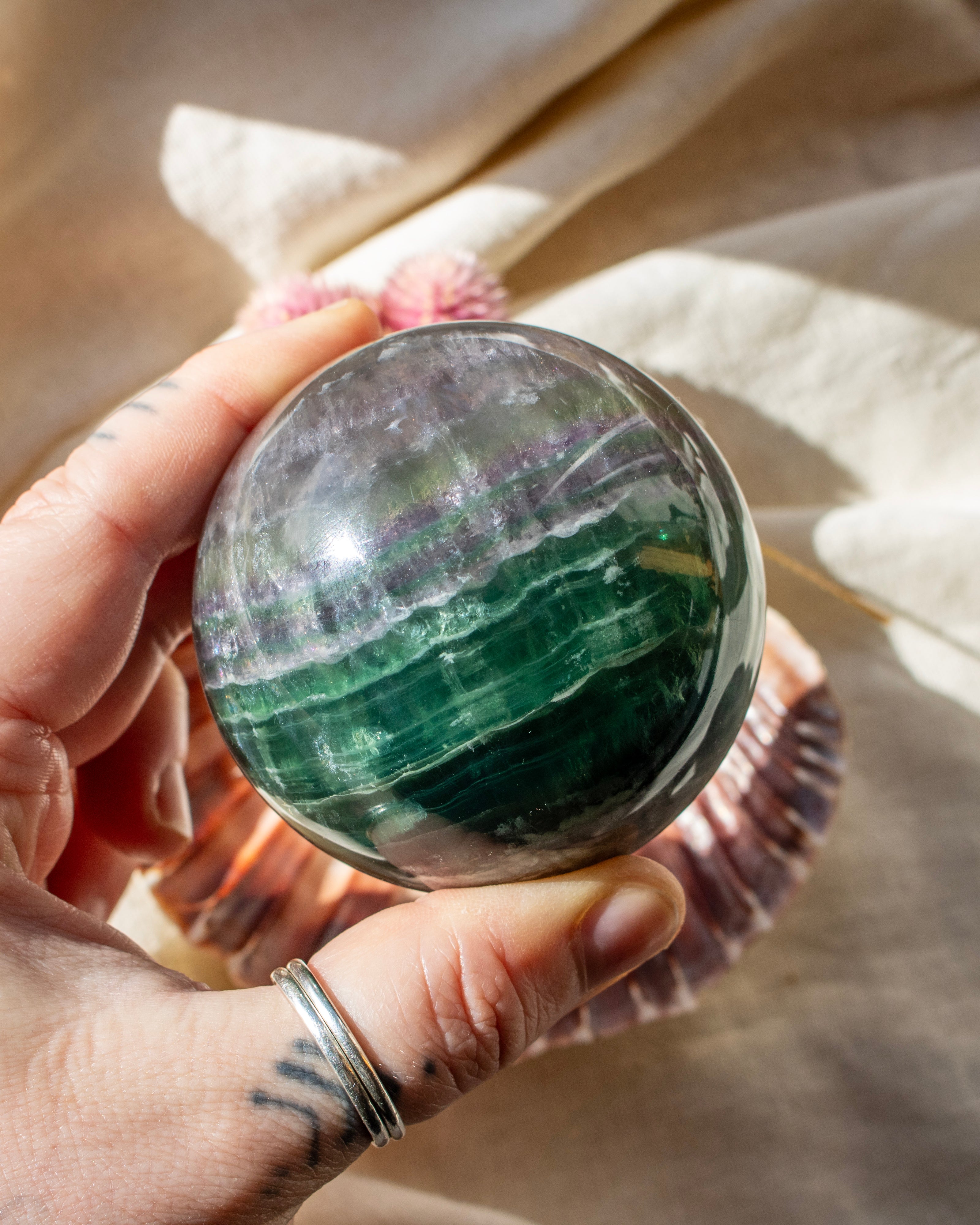 Hand holding a colorful crystal ball with a soft, blurred background