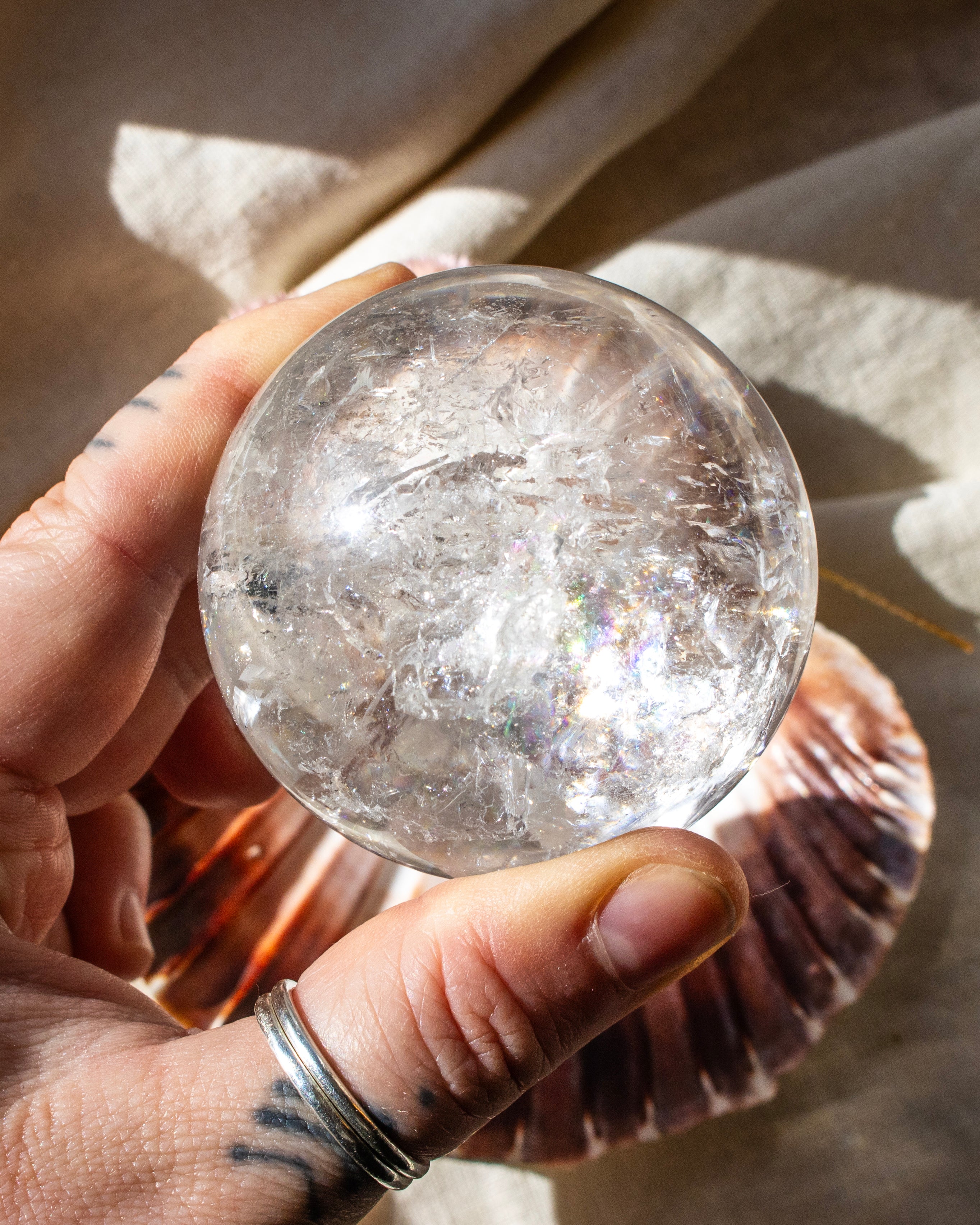 Clear crystal ball held in a hand with a blurred background