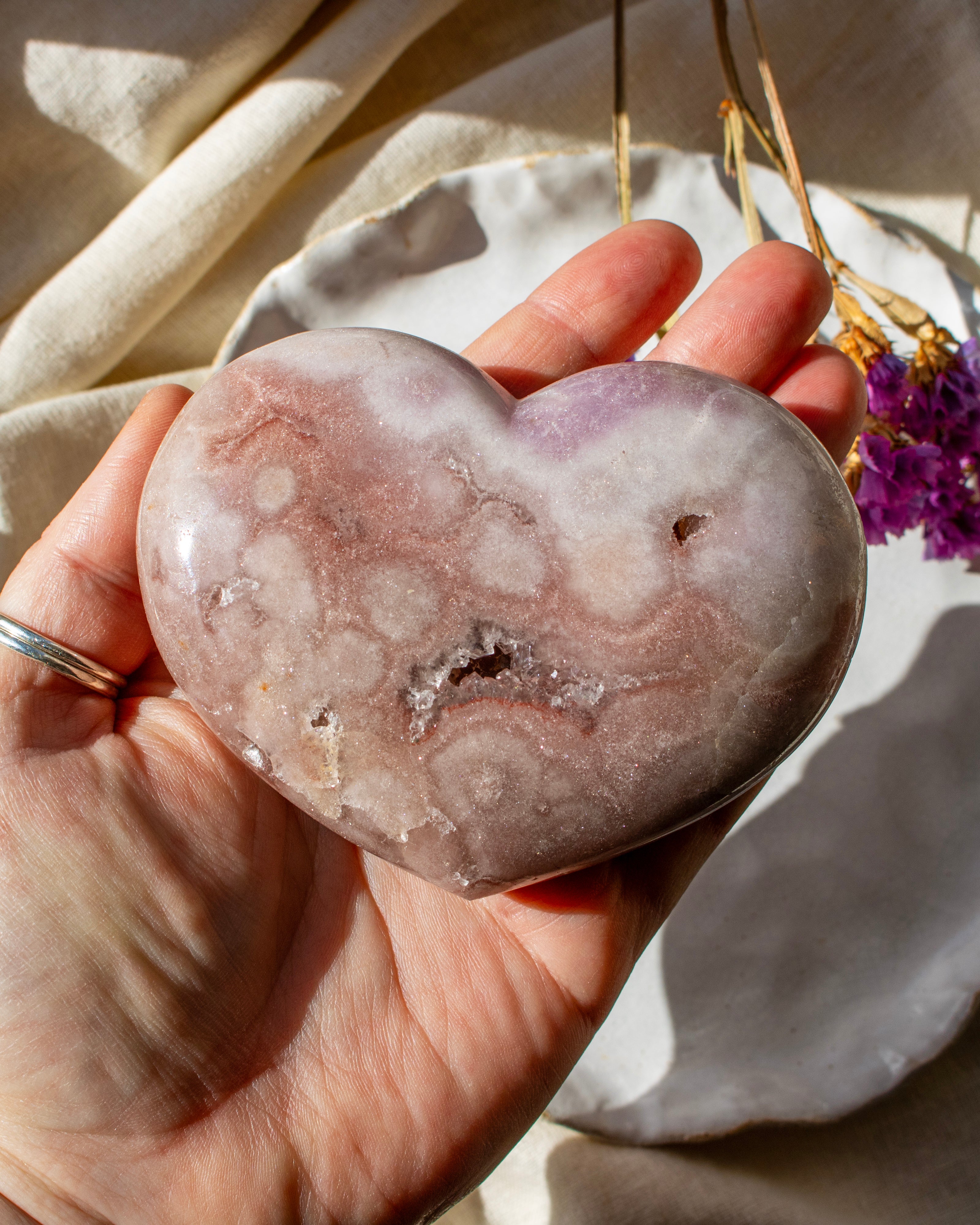 Heart-shaped stone held in a hand with a soft, blurred background