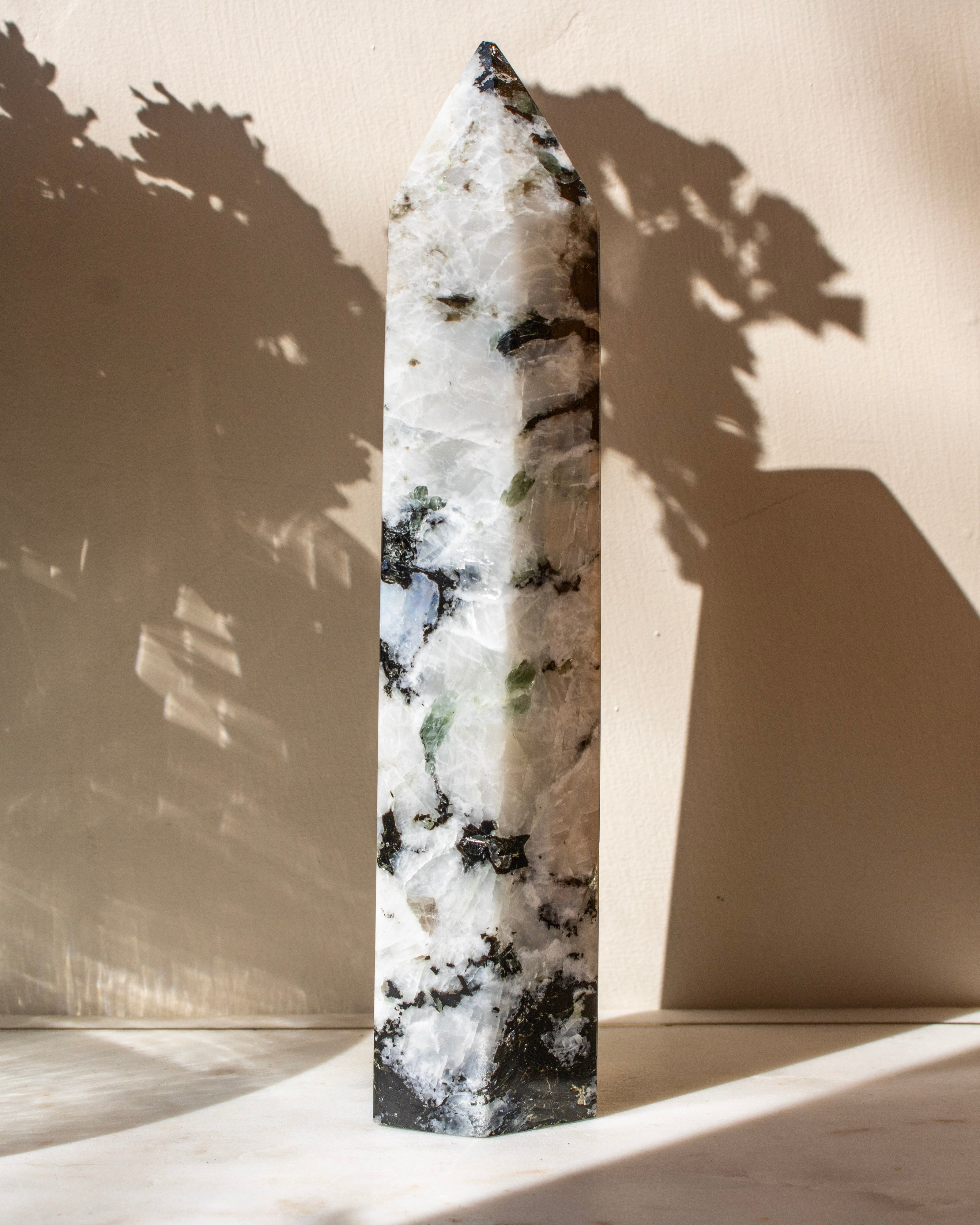 Crystal obelisk with black markings on a beige background