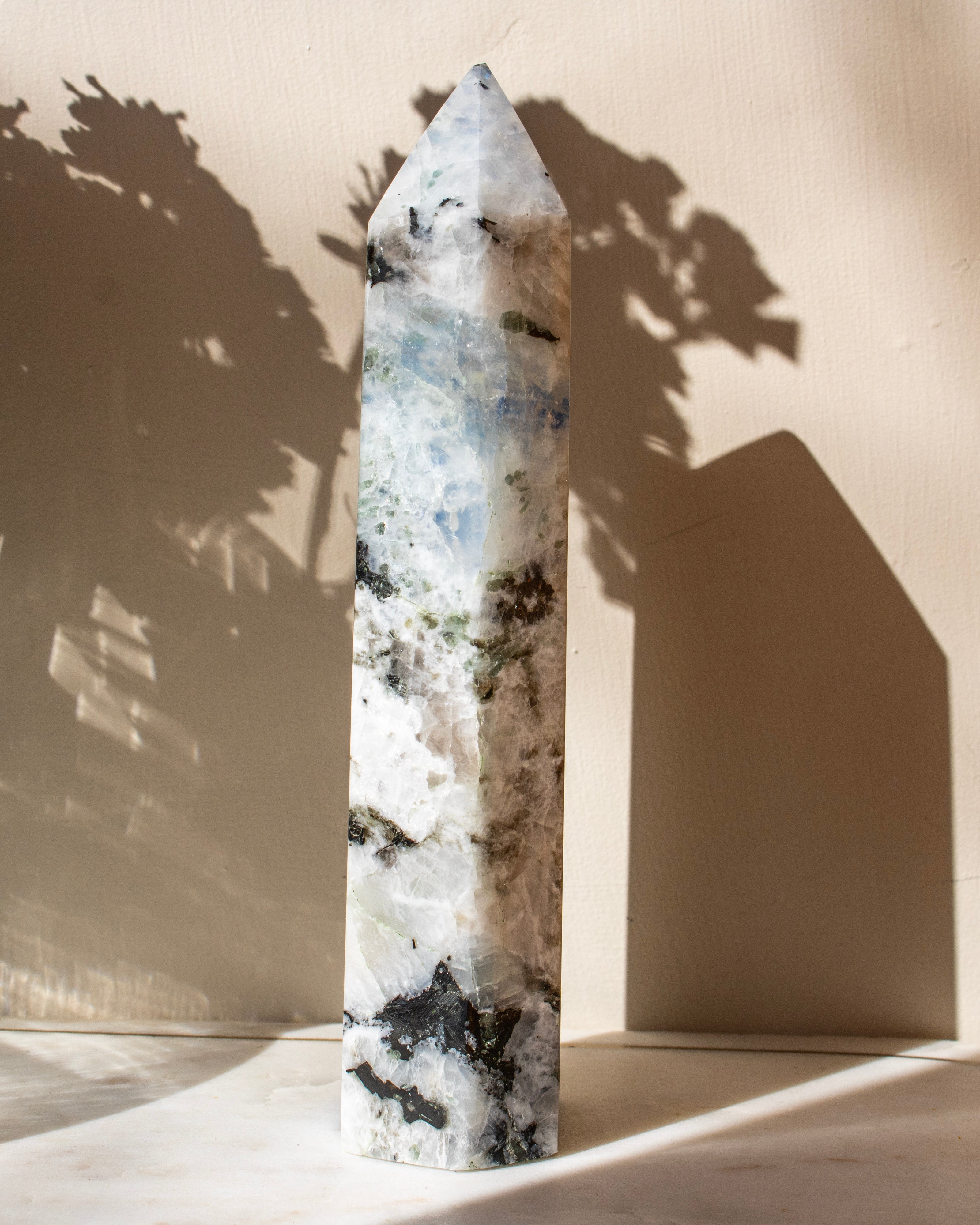 Decorative crystal tower against a beige wall with shadows