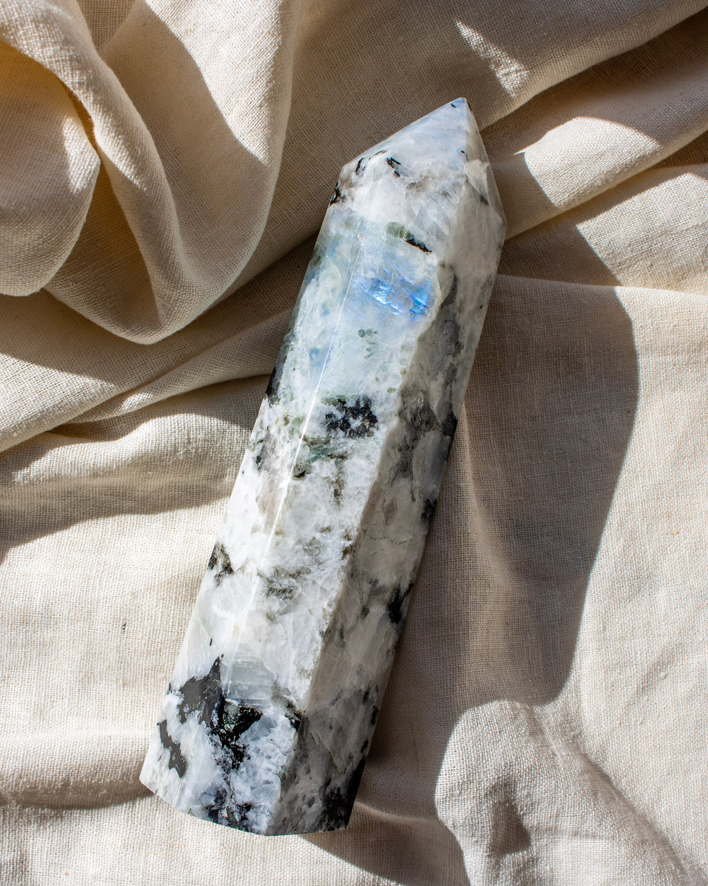 Crystal wand with a natural stone texture on a beige fabric background