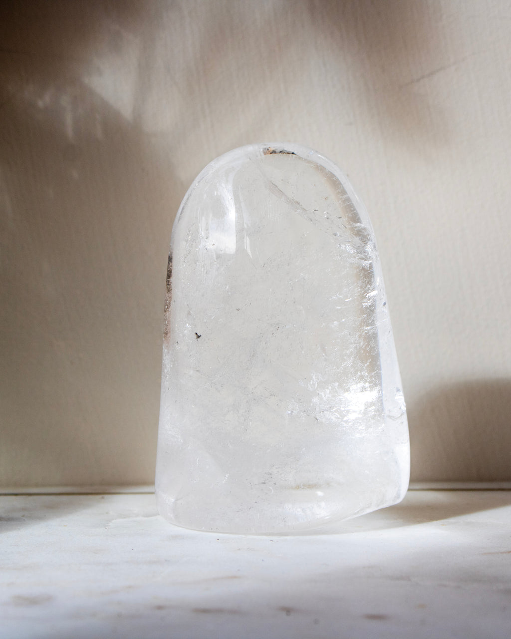 a clear quartz stone against a beige background