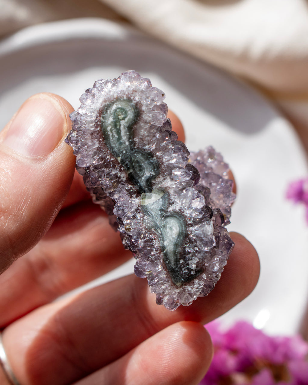 Hand holding a crystal with a question mark symbol, blurred background