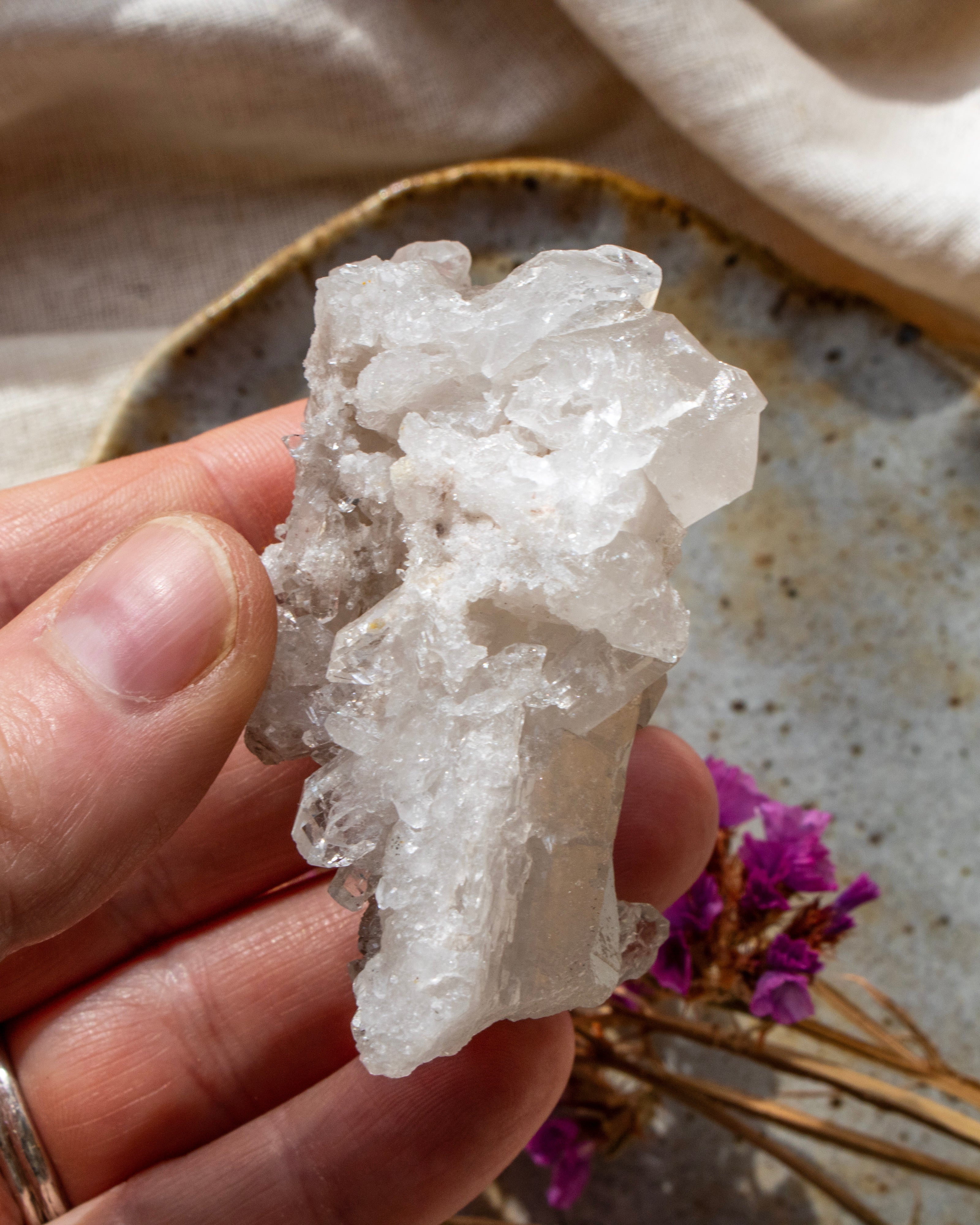 Hand holding a crystal rock with a blurred background