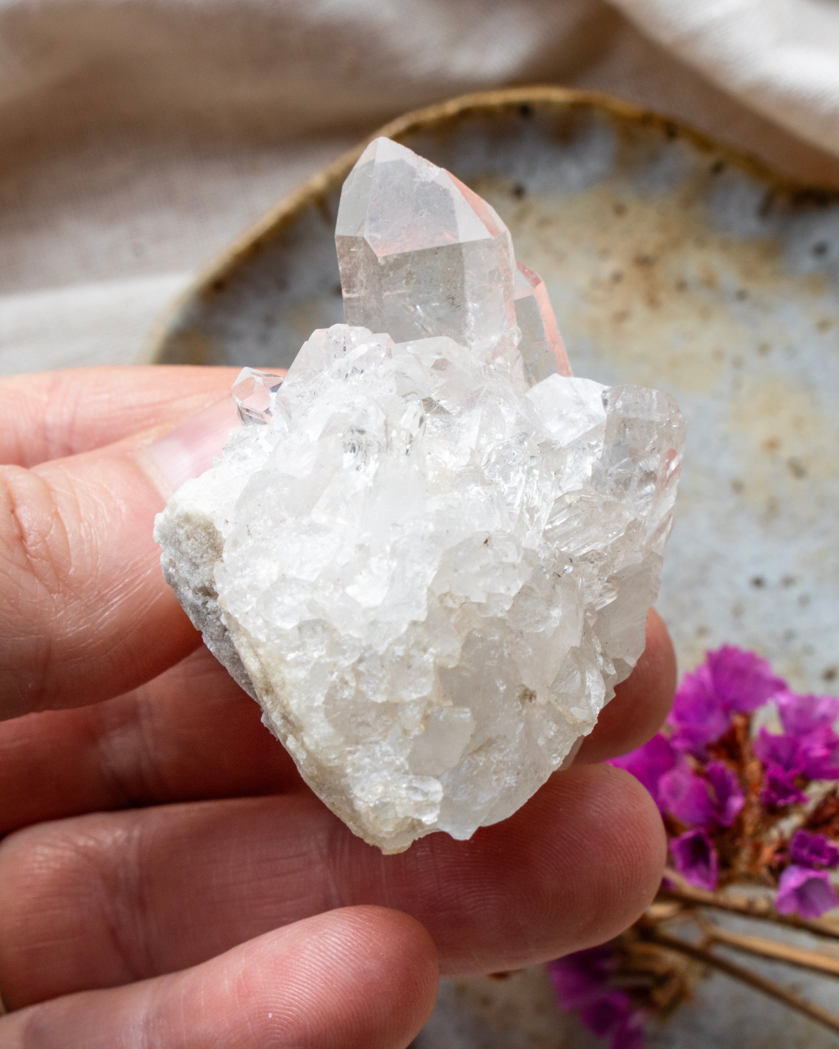 Hand holding a crystal cluster with a blurred background