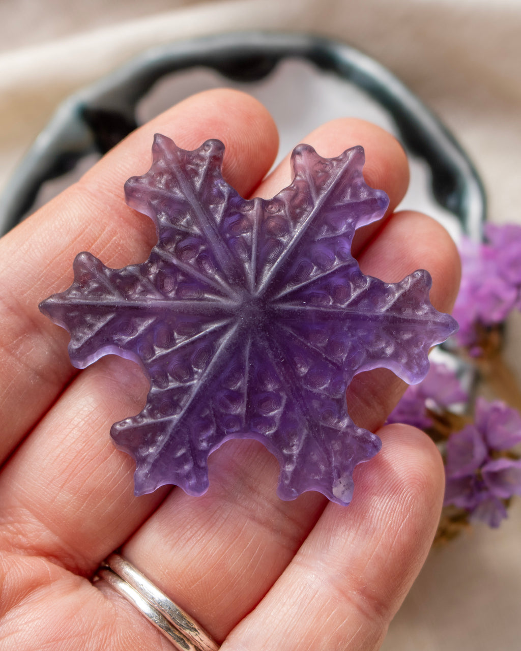 a purple snowflake being held with a blurred background