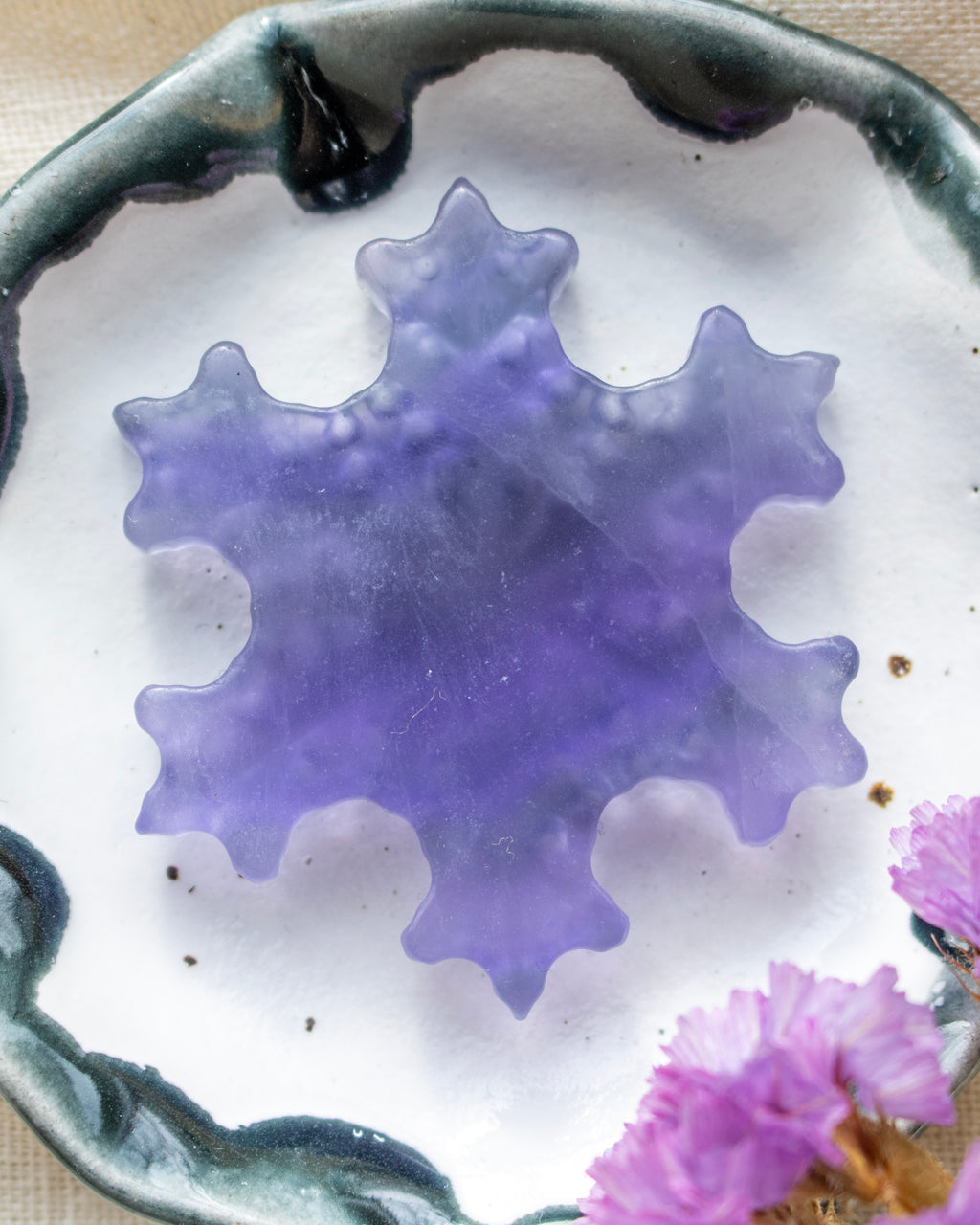 a purple snowflake on a white and navy blue ceramic dish