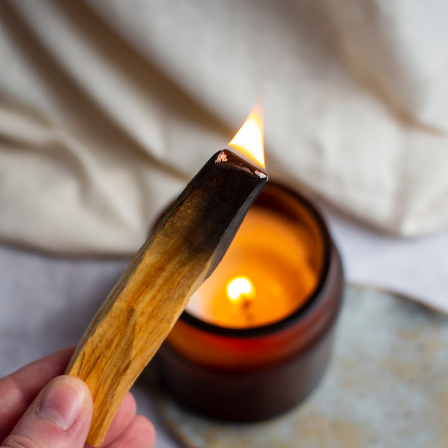 A Palo Santo stick with a flame at its tip, emitting a gentle light.