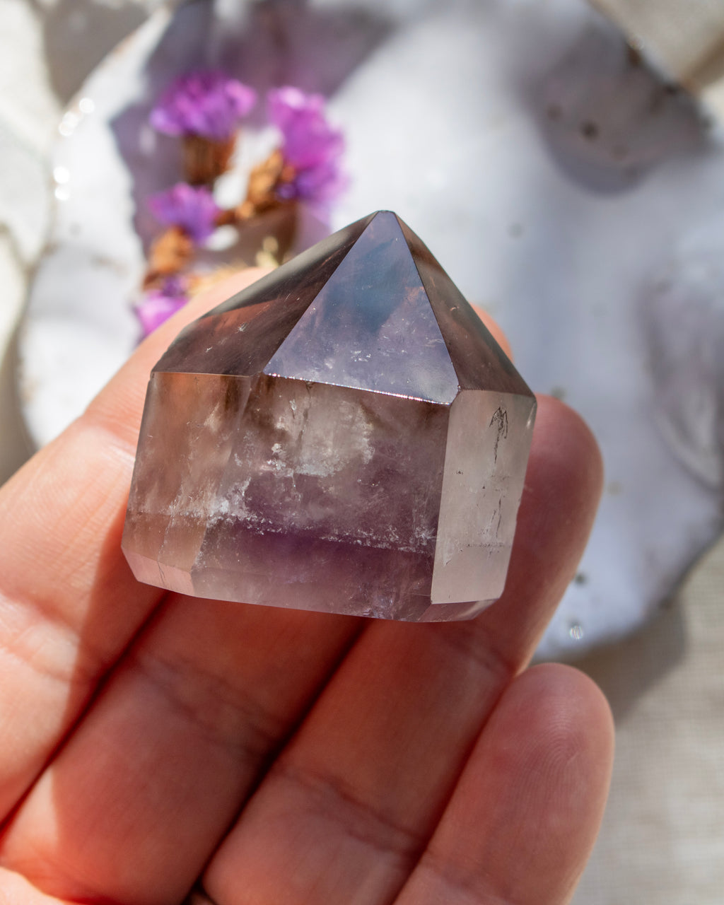Crystal point held in a hand with a blurred background