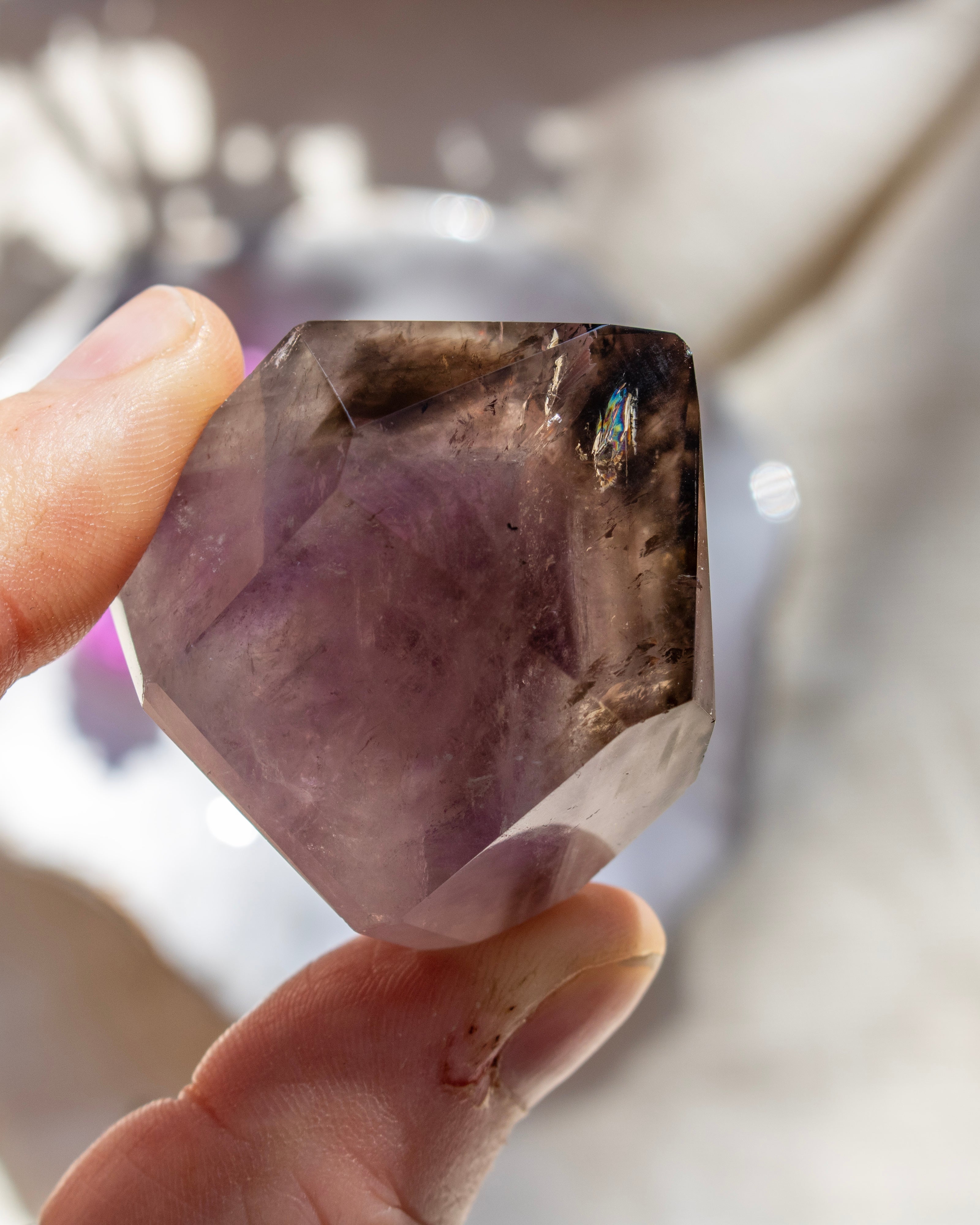 Person holding a purple crystal with a blurred background