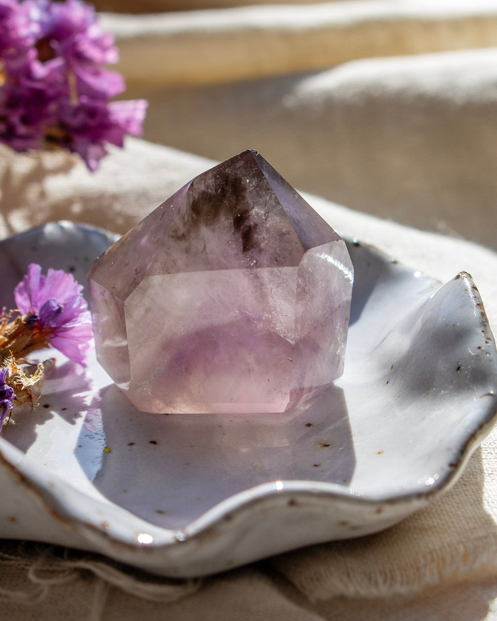 Crystal on a white dish with purple flowers